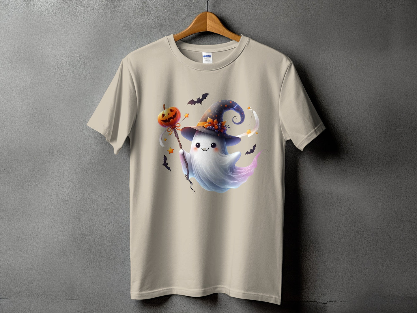Tan t-shirt with a cute ghost in a witch hat holding a pumpkin wand.