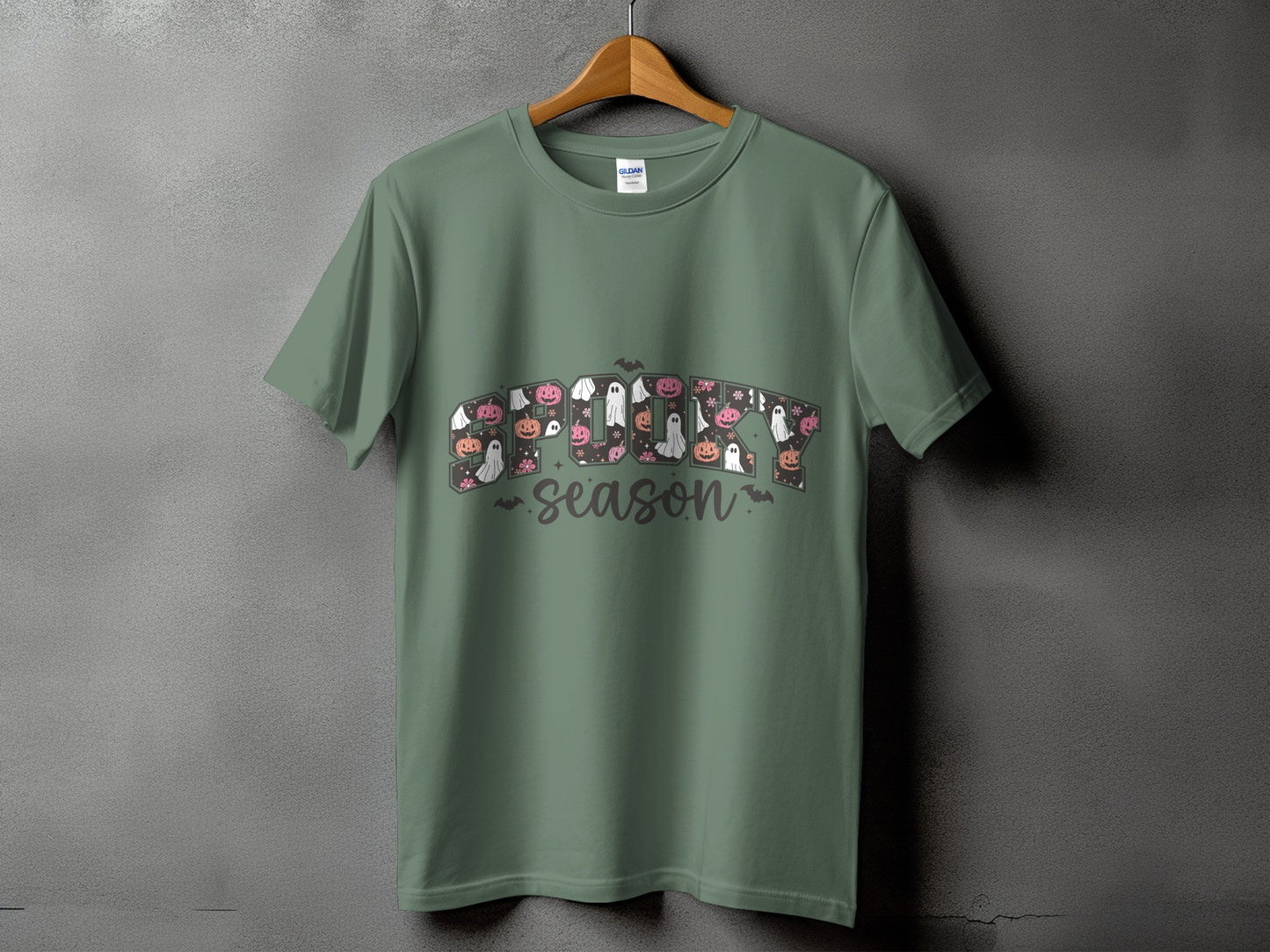 Green t-shirt with "Spooky Season" text featuring pumpkins, ghosts, and flowers.