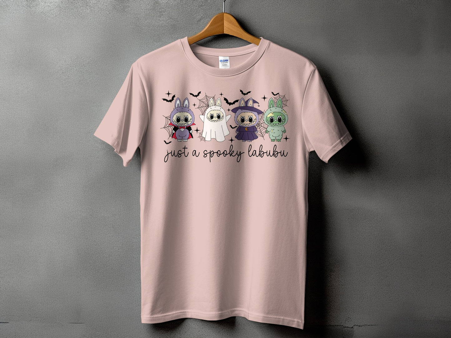 Pink t-shirt with four Halloween-themed characters and the text "just a spooky labubu."