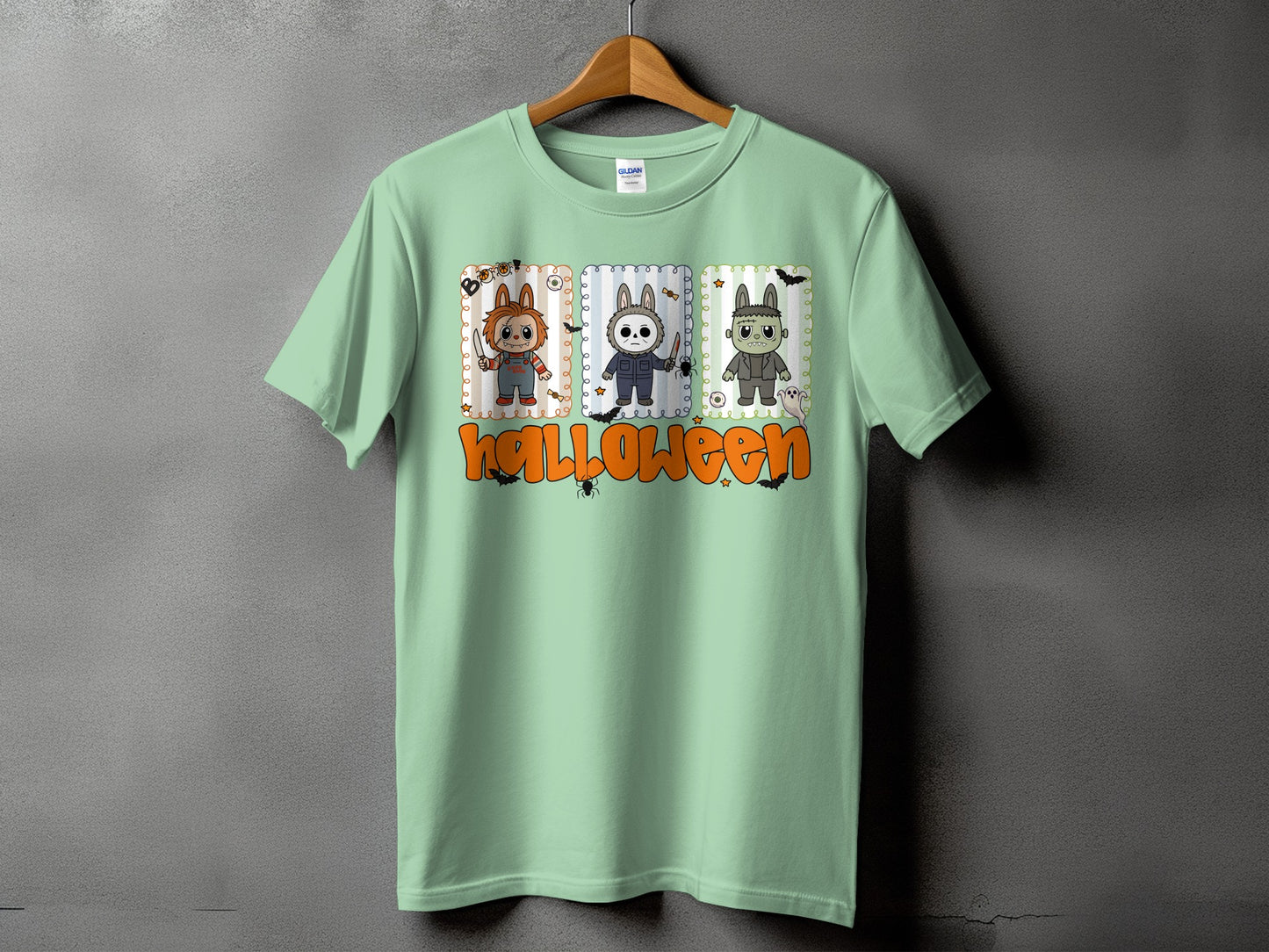 Mint t-shirt with three cartoon horror characters and the word Halloween.