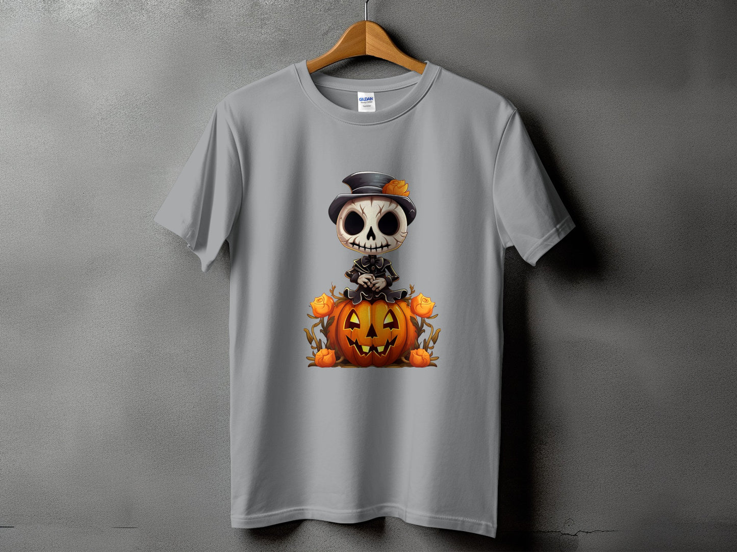 Skeleton in a top hat sits on a jack-o'-lantern with roses on a gray t-shirt.