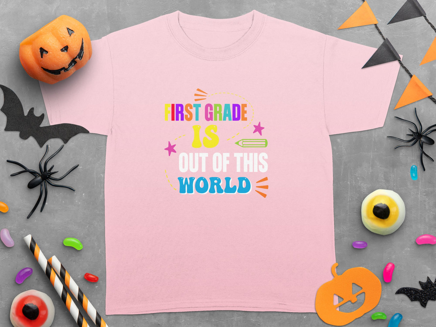 Pink t-shirt with "First Grade Is Out of This World" text and Halloween decorations.
