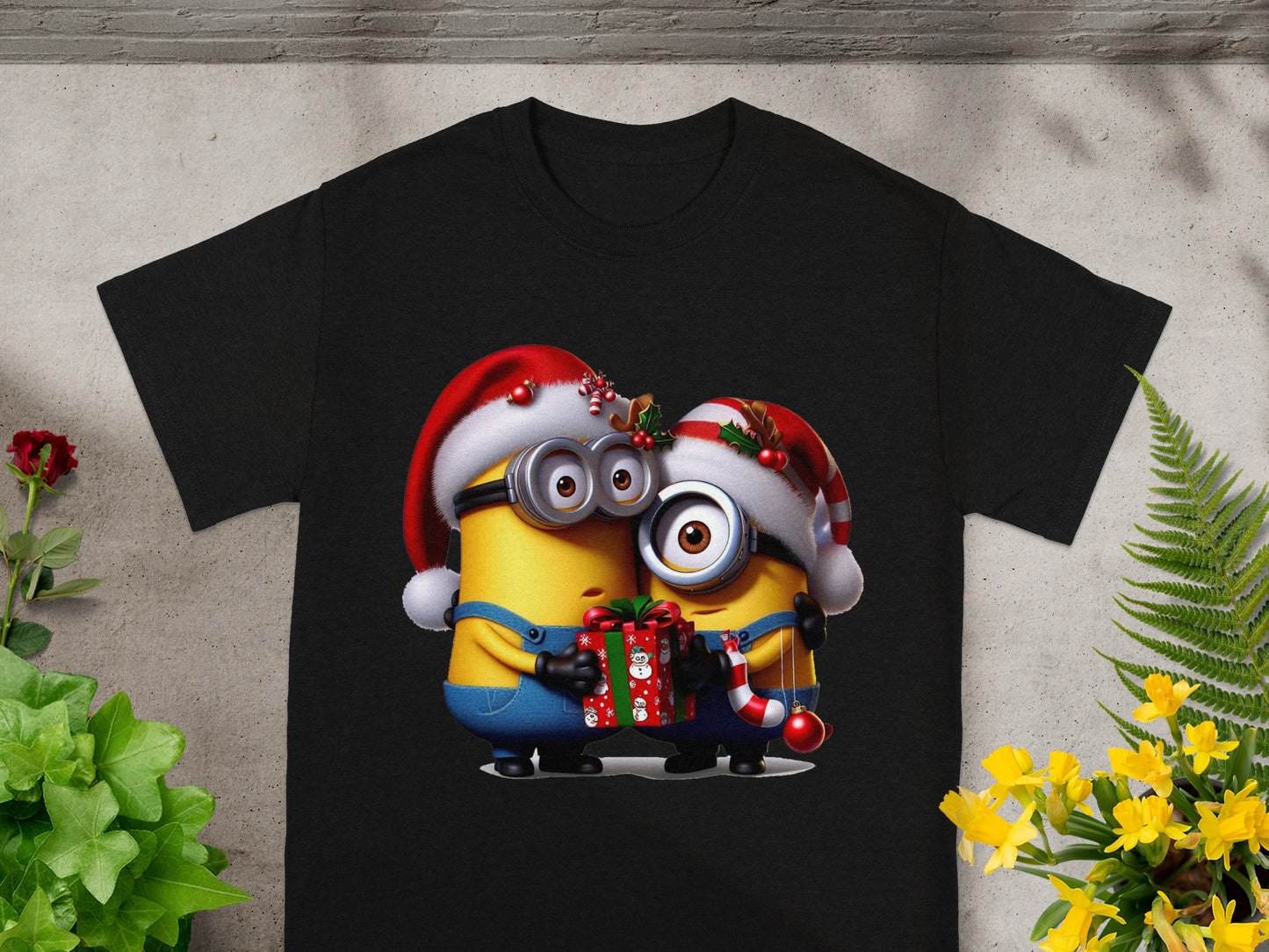Two Minions in Santa hats hug holding a gift and Christmas candy cane.