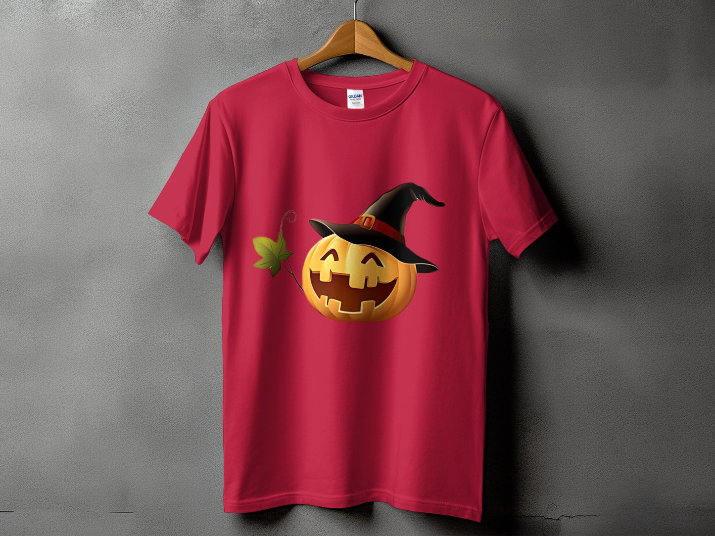 Red t-shirt with a smiling jack-o'-lantern wearing a witch hat and a green leaf.