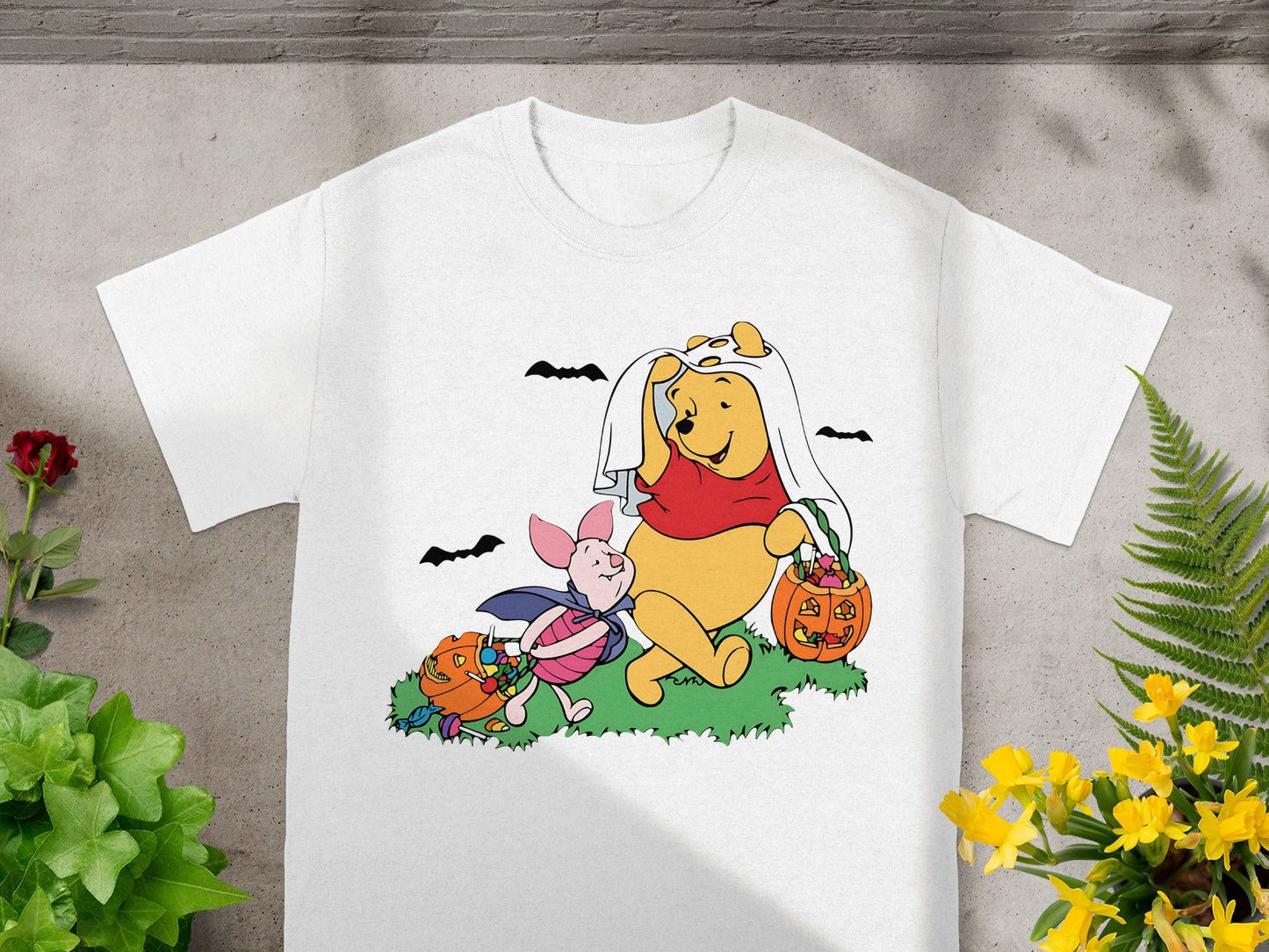 Winnie the Pooh and Piglet in Halloween costumes with candy and pumpkins.