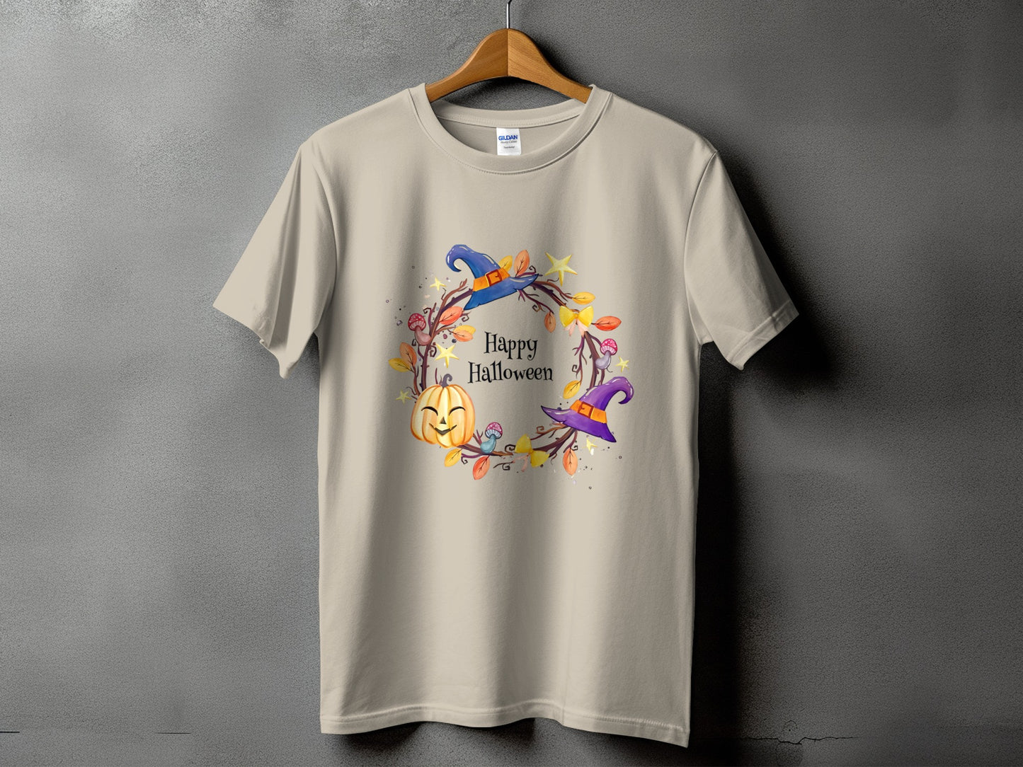 Light tan t-shirt with "Happy Halloween" and a wreath of pumpkins, witches hats, and leaves.