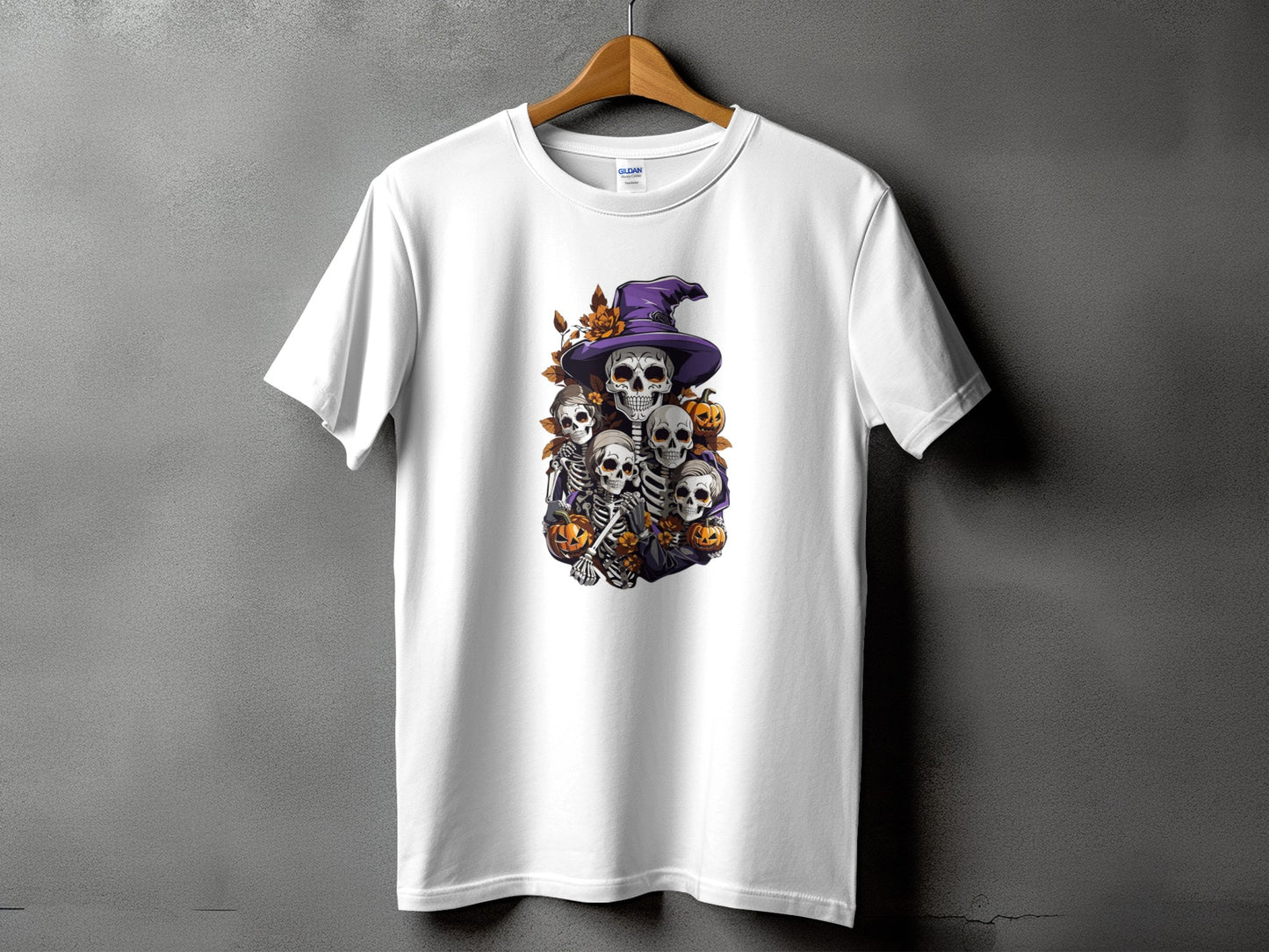 White t-shirt with a Halloween graphic of skeletons under a witch hat.