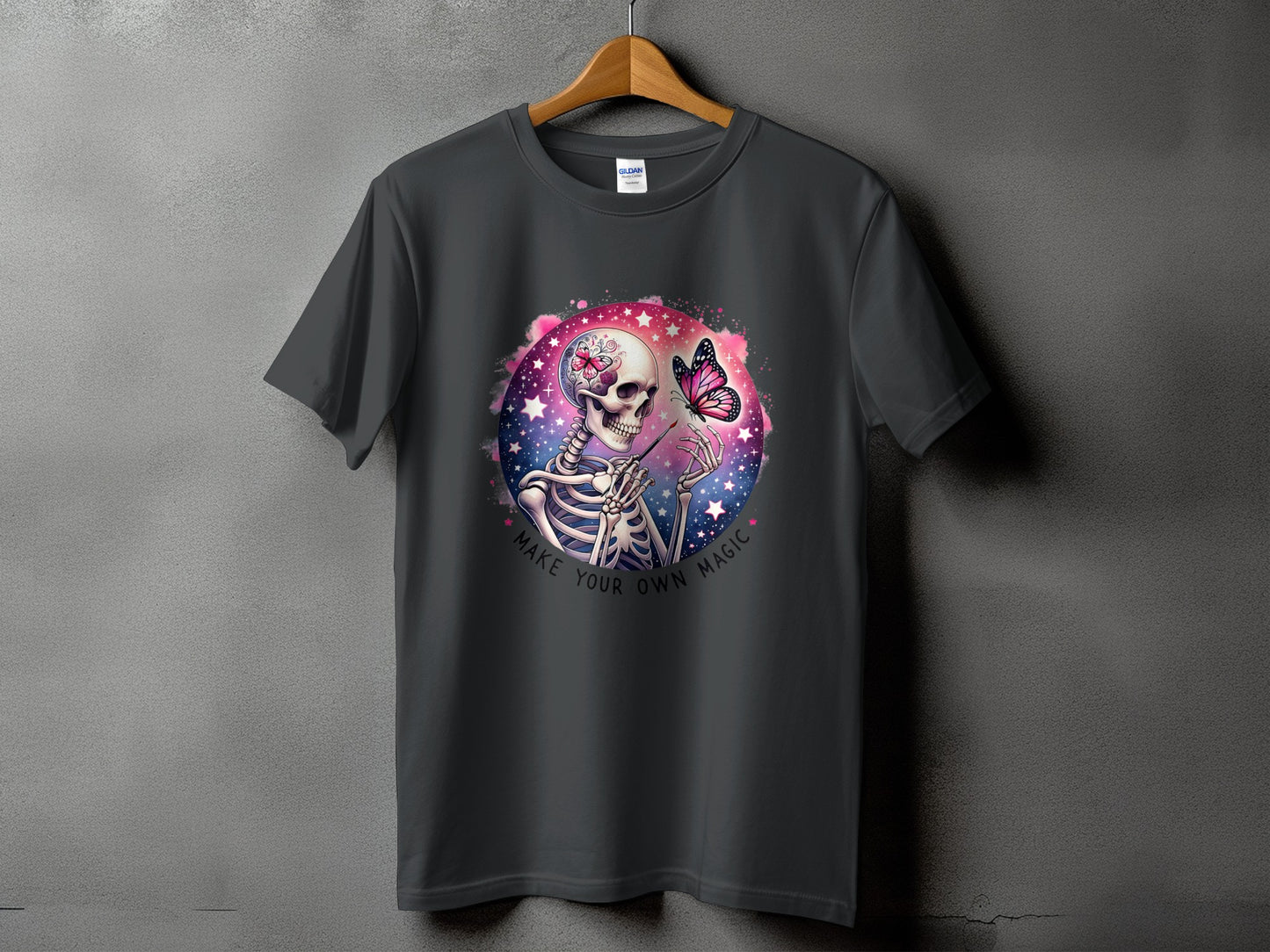 Skeleton holding a paintbrush with a butterfly on a starry, pink background, text "Make Your Own Magic."