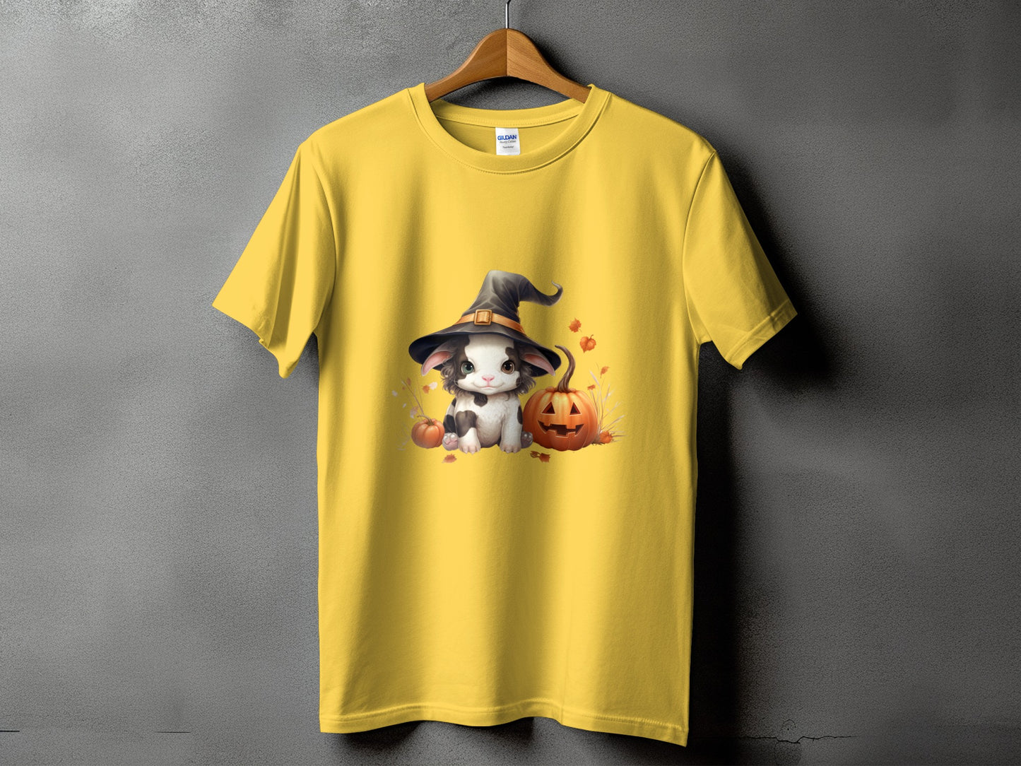 Yellow t-shirt with a cute cow wearing a witch hat and pumpkins.