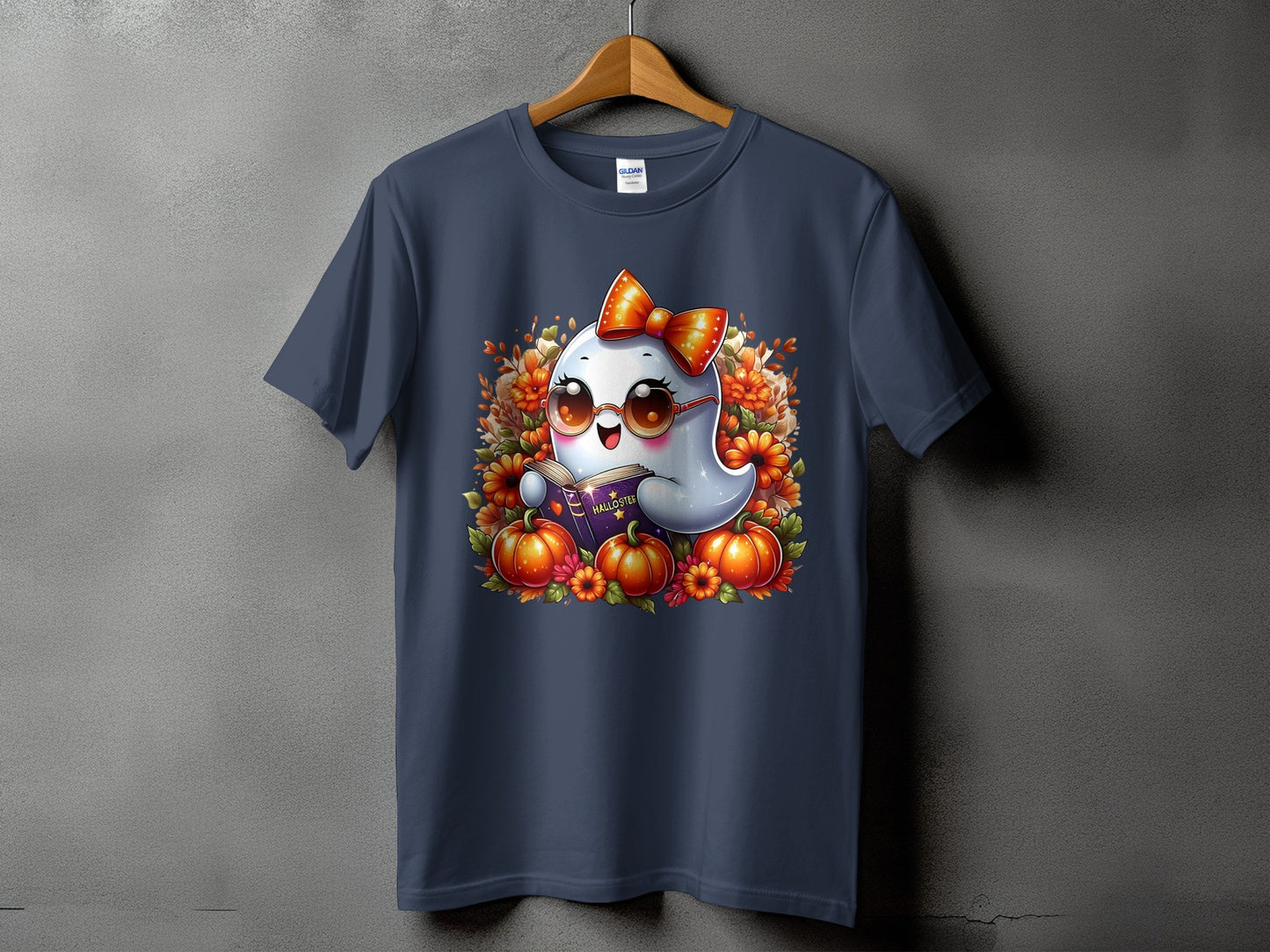 Dark blue t-shirt with a cute ghost reading a book surrounded by pumpkins and flowers.