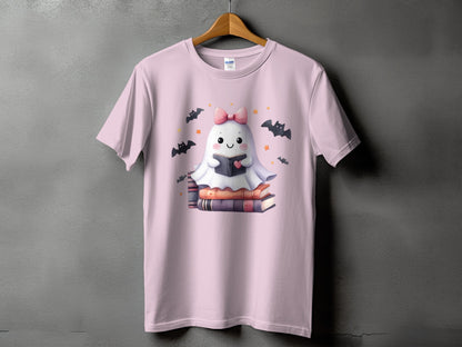 Pink t-shirt with a cute ghost reading a book surrounded by bats and stars.