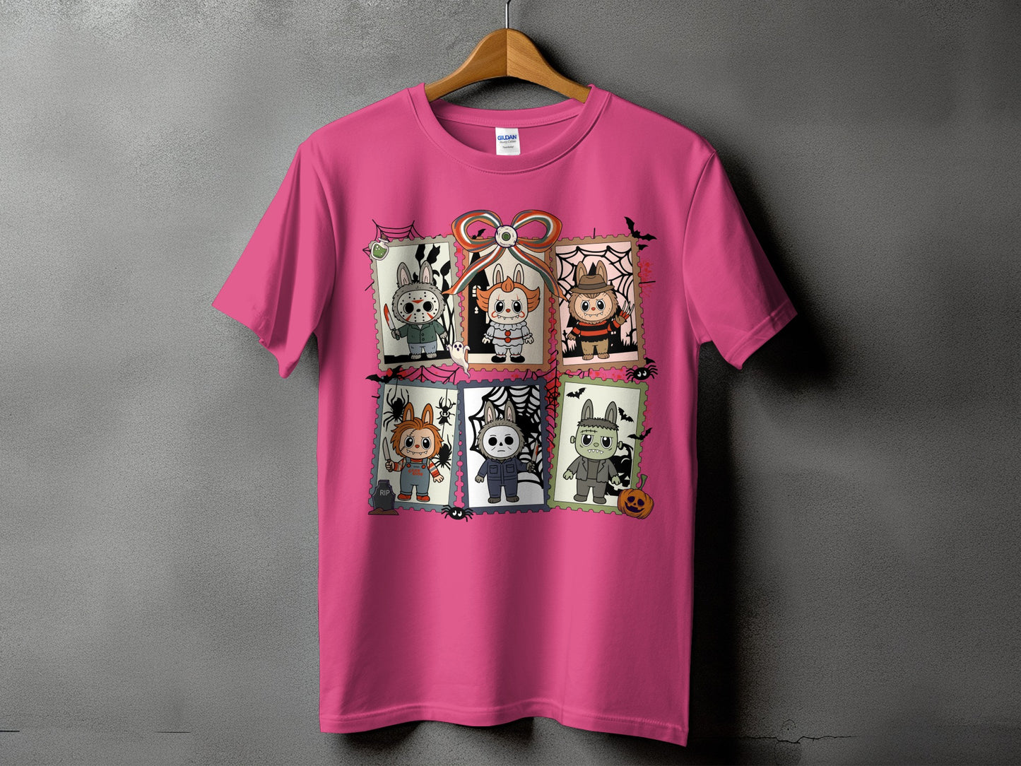 Pink t-shirt with six framed Halloween character illustrations, including a clown and a monster.