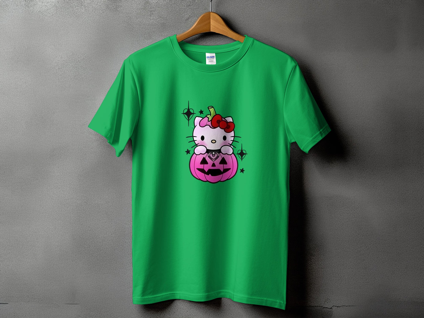Green t-shirt with Hello Kitty sitting in a pink Halloween pumpkin.