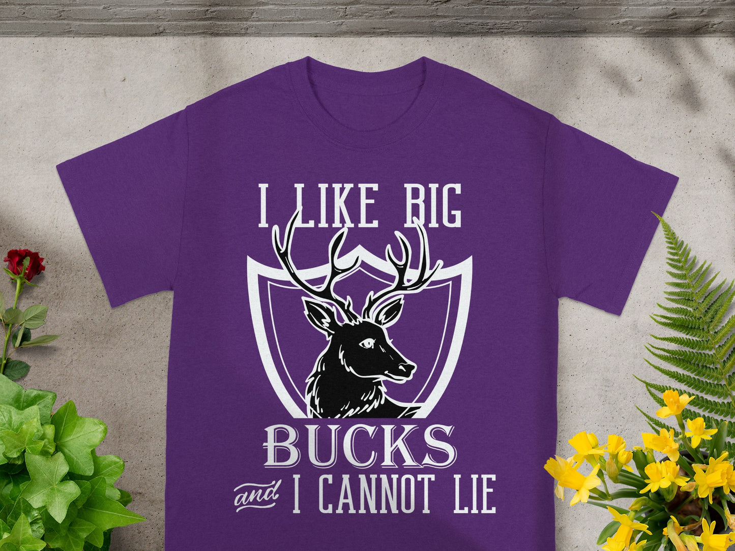 Purple t-shirt with white text "I LIKE BIG BUCKS and I CANNOT LIE" and deer graphic.