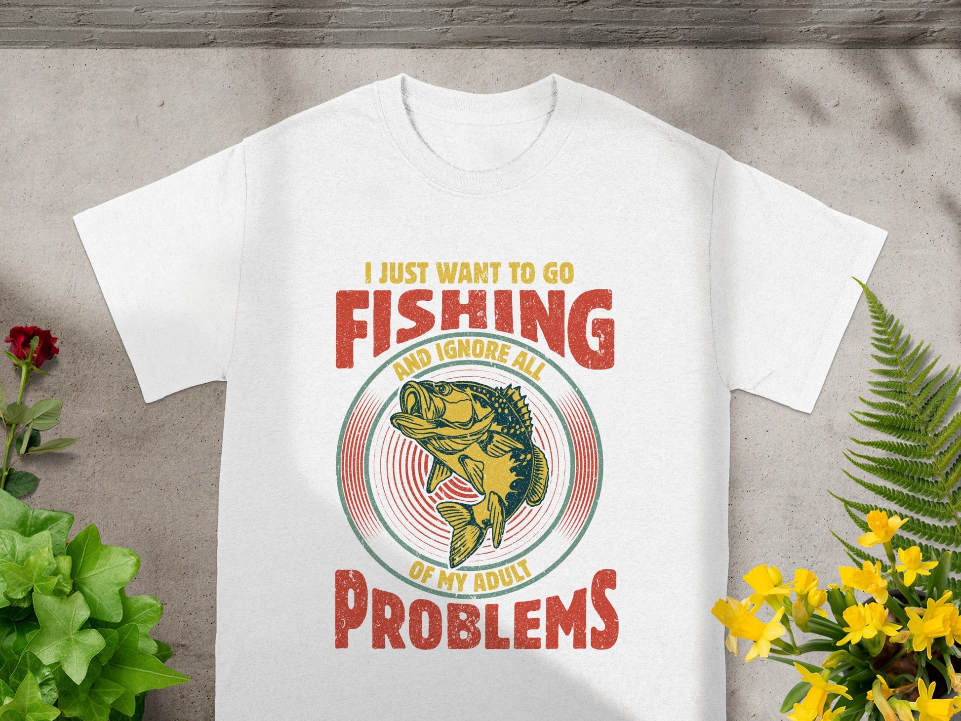 White t-shirt with text "I just want to go fishing and ignore all of my adult problems" and a fish graphic.