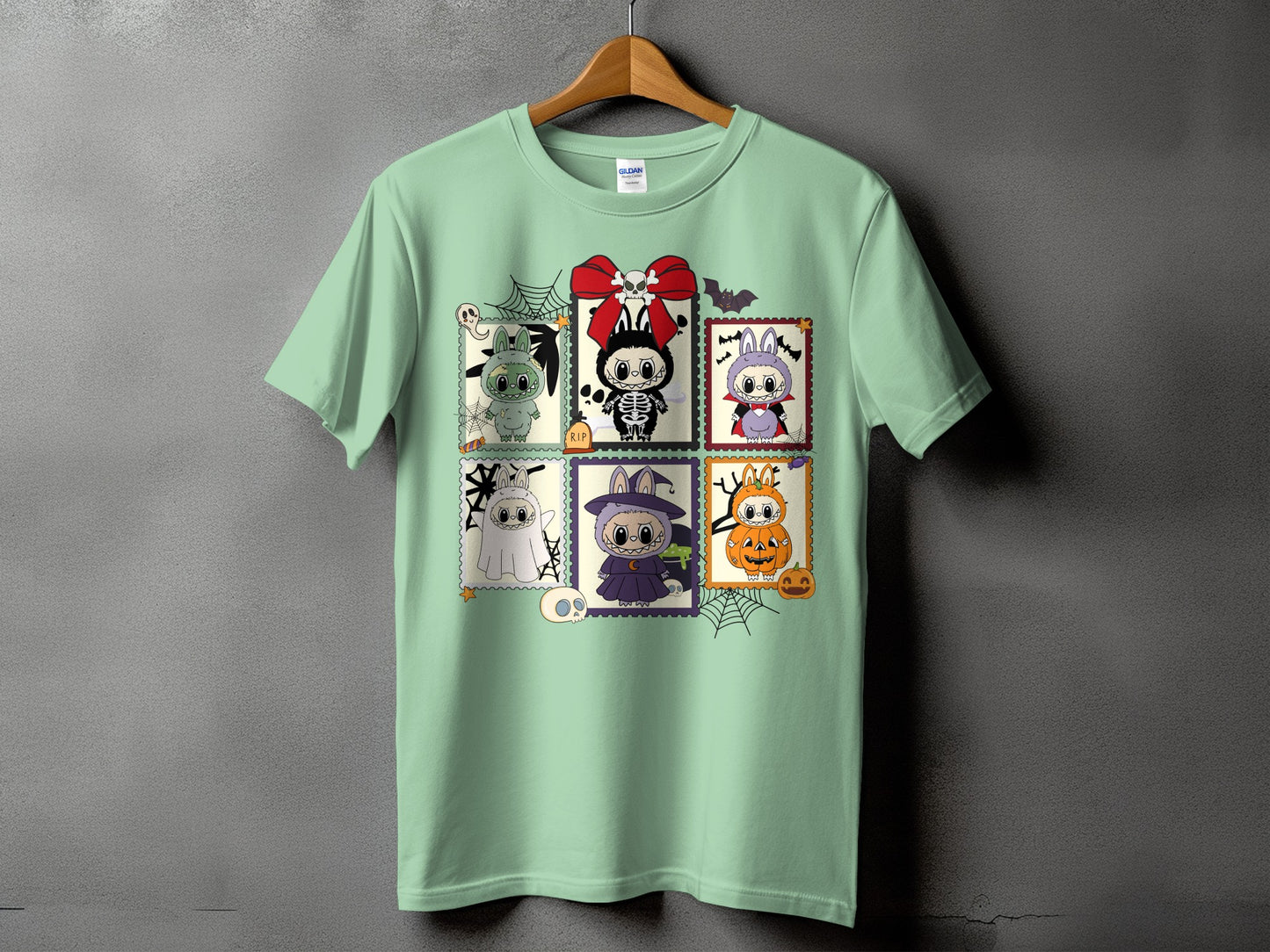 Mint green t-shirt with Halloween-themed cartoon characters in postage stamp frames.
