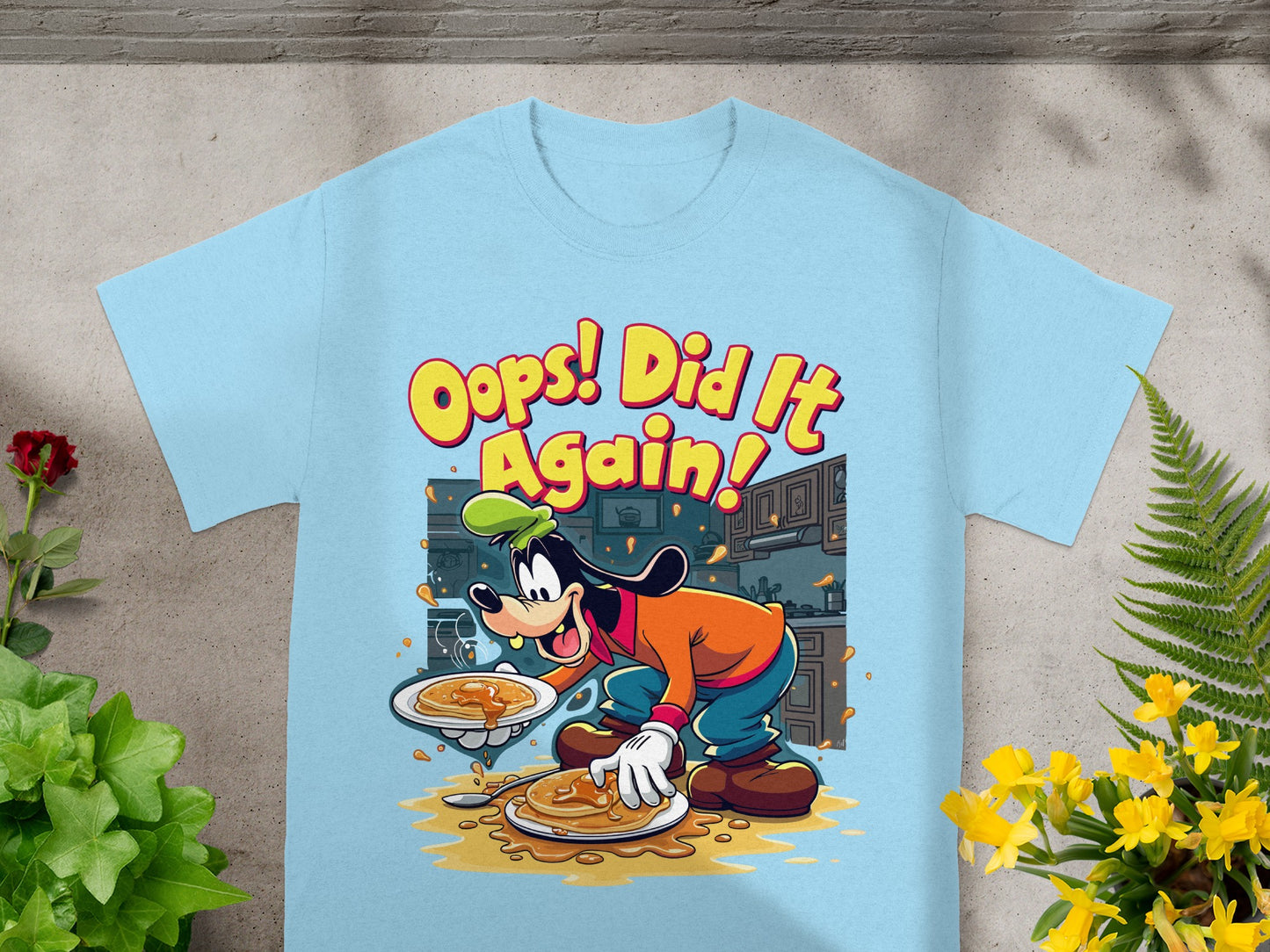 Goofy spilling pancakes from a plate onto a light blue t-shirt.