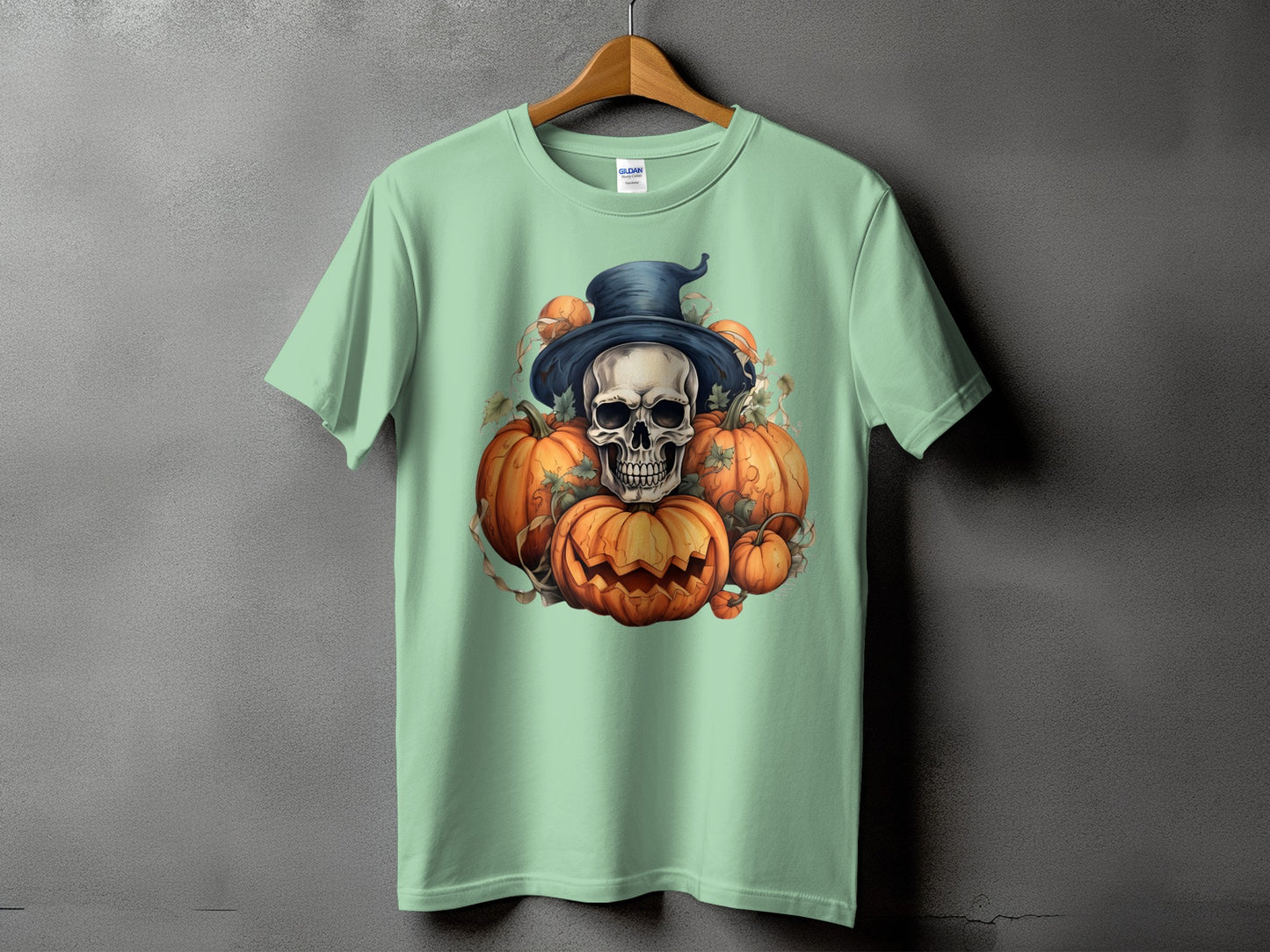 Mint green t-shirt with a Halloween graphic of a skull, witch hat, and pumpkins.