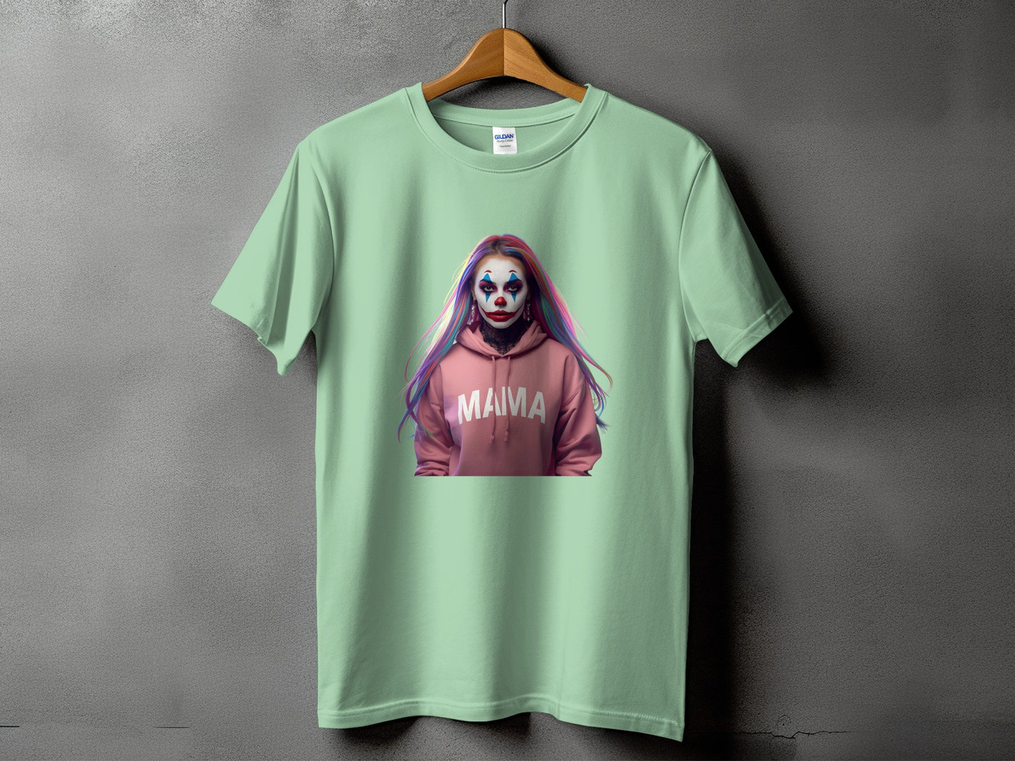 Light green t-shirt with a pink hoodie graphic featuring a clown face and "MAMA" text.