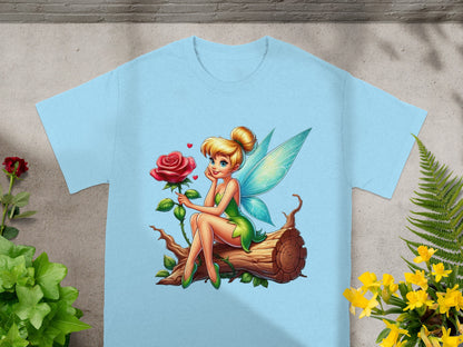 Fairy with rose sits on a log, wearing green outfit.
