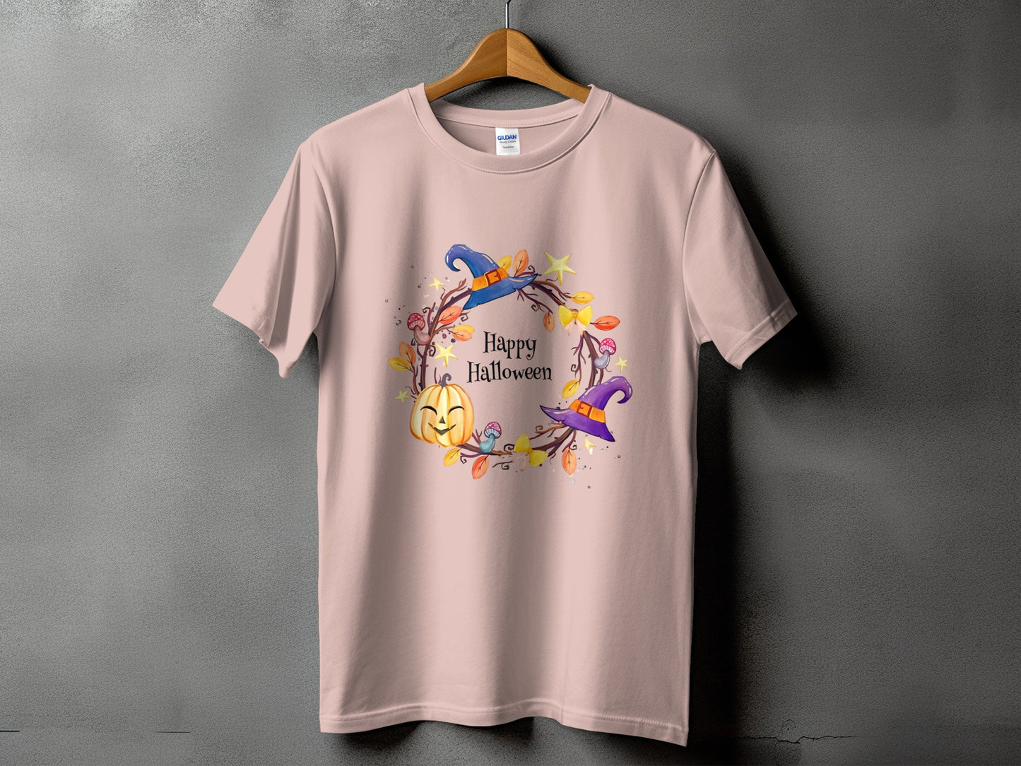 Pink t-shirt with a circular Halloween graphic featuring a pumpkin and witch hats.