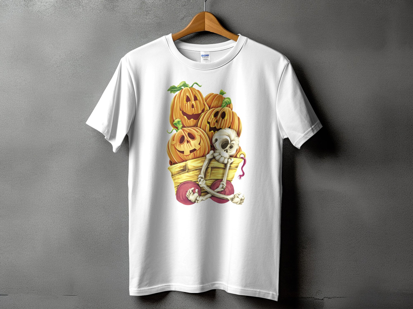 White t-shirt with a Halloween graphic of carved pumpkins and a skeleton in a wagon.