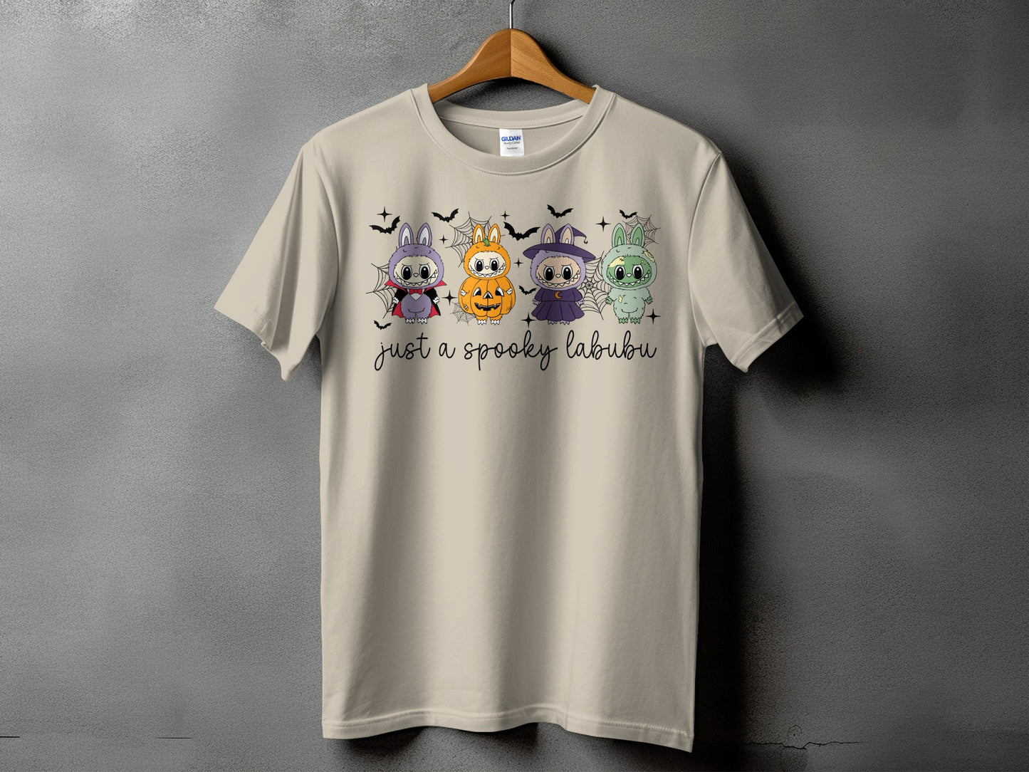 T-shirt with four cartoon Halloween creatures and text "just a spooky labubu".