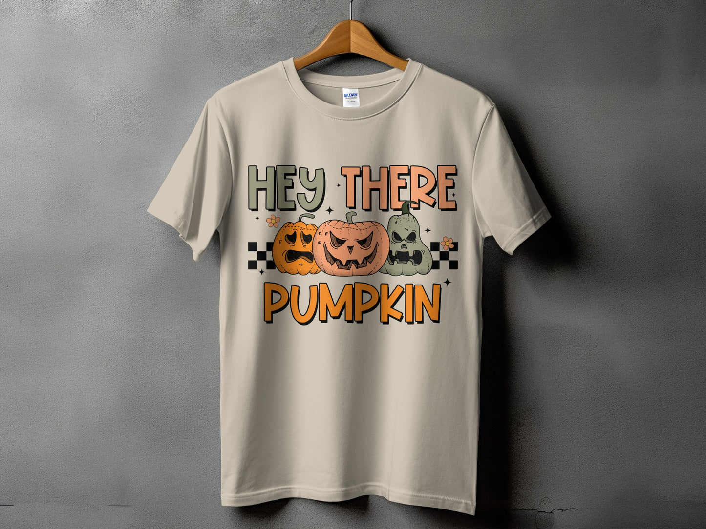 Light beige t-shirt with "HEY THERE PUMPKIN" text and three carved pumpkins.