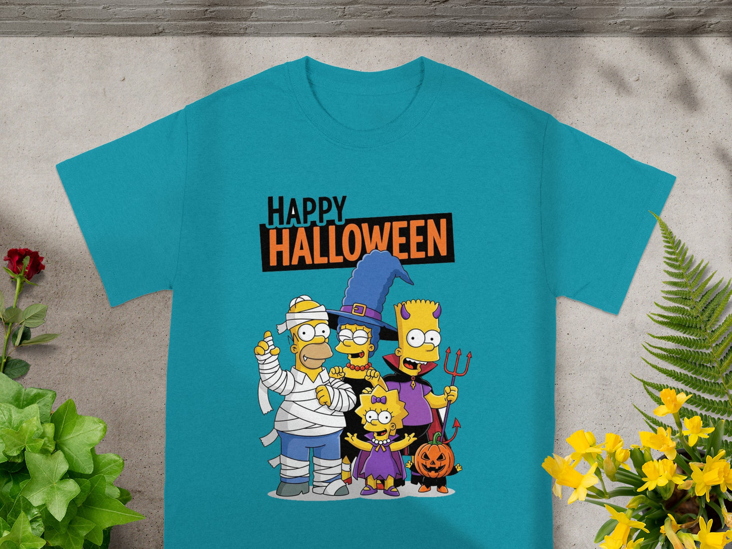 Simpsons family in Halloween costumes with "Happy Halloween" text on a teal t-shirt.