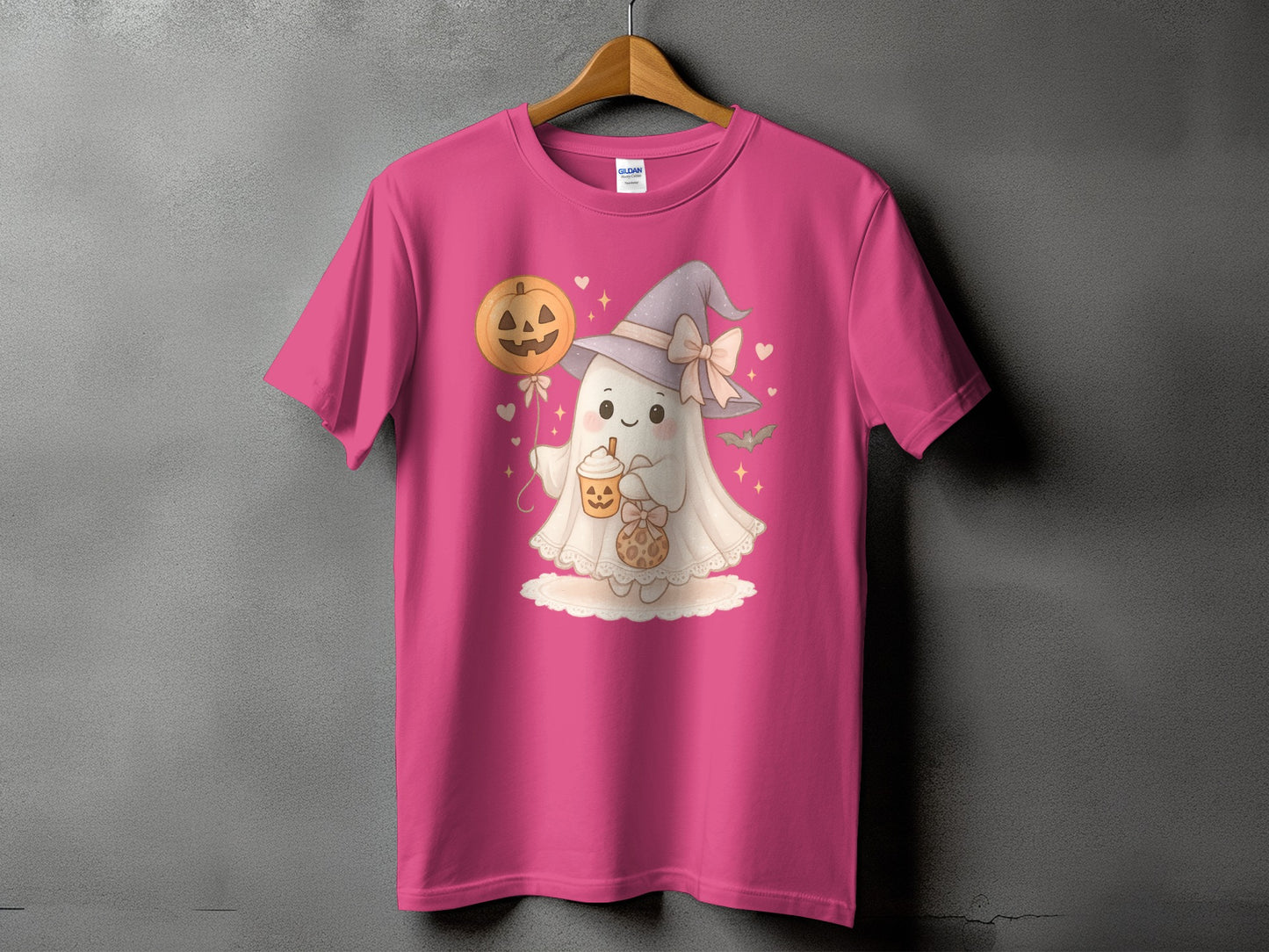 Pink t-shirt with a cute ghost wearing a witch hat and holding a pumpkin drink.