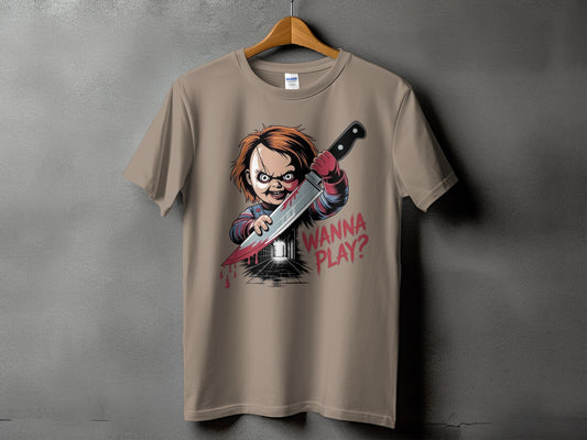 Chucky doll with knife and "WANNA PLAY?" text on tan t-shirt.