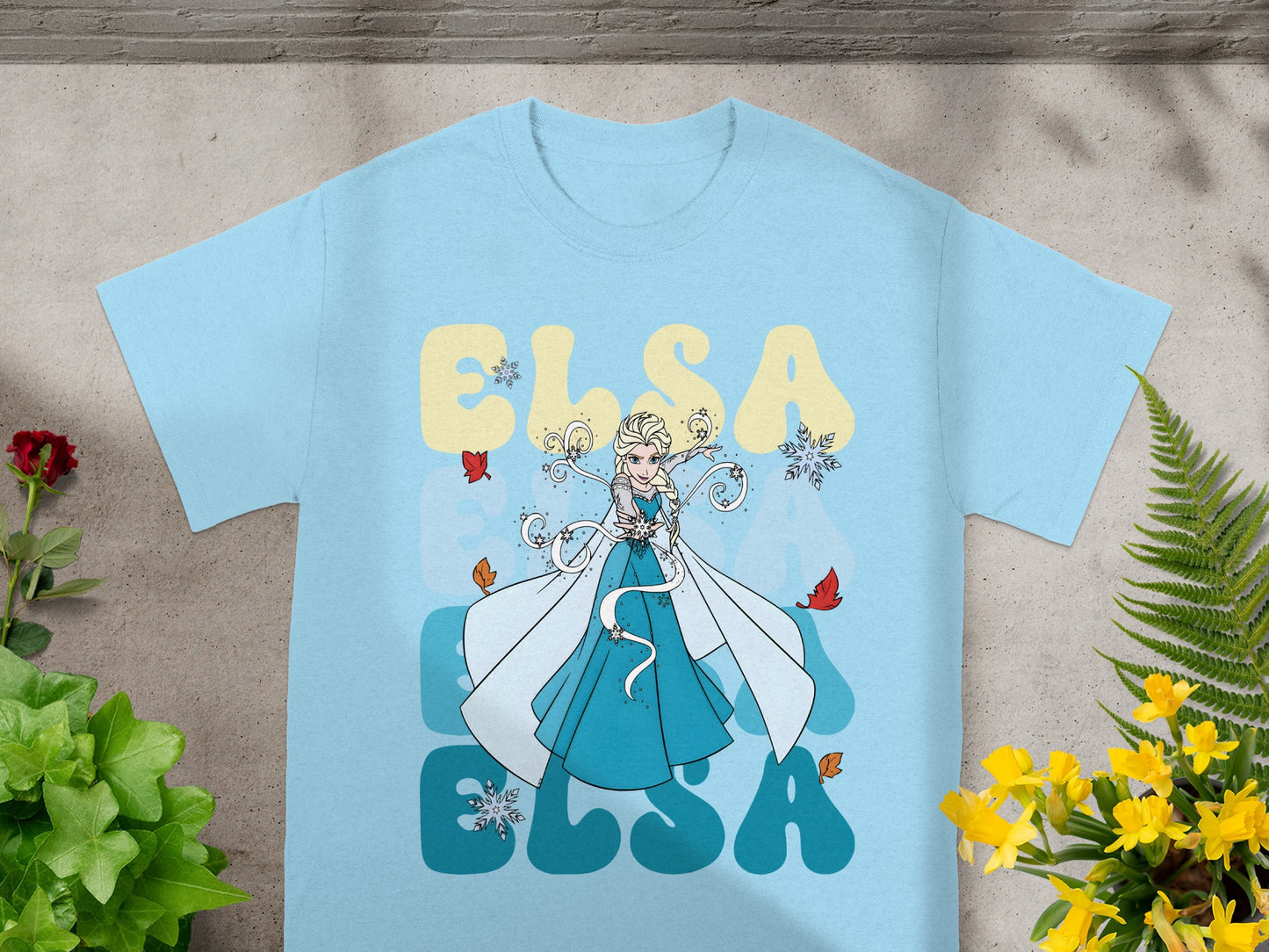 Light blue t-shirt with Elsa graphic and text in yellow and blue.