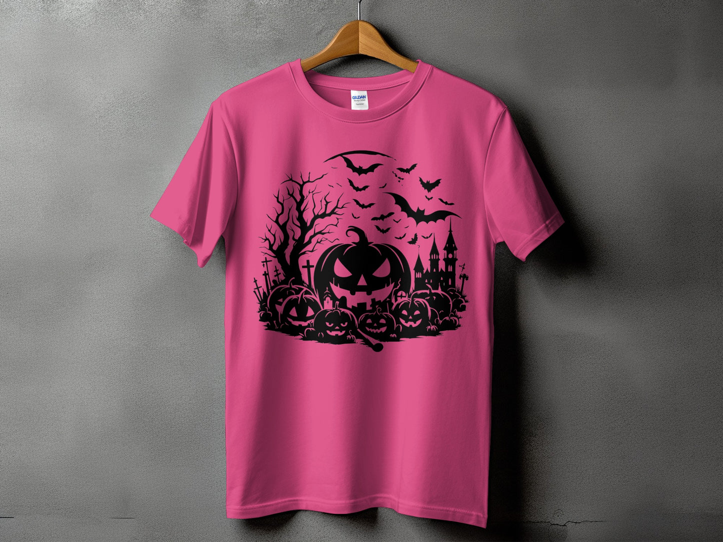 Pink t-shirt with a black Halloween graphic featuring pumpkins, bats, and a haunted castle.