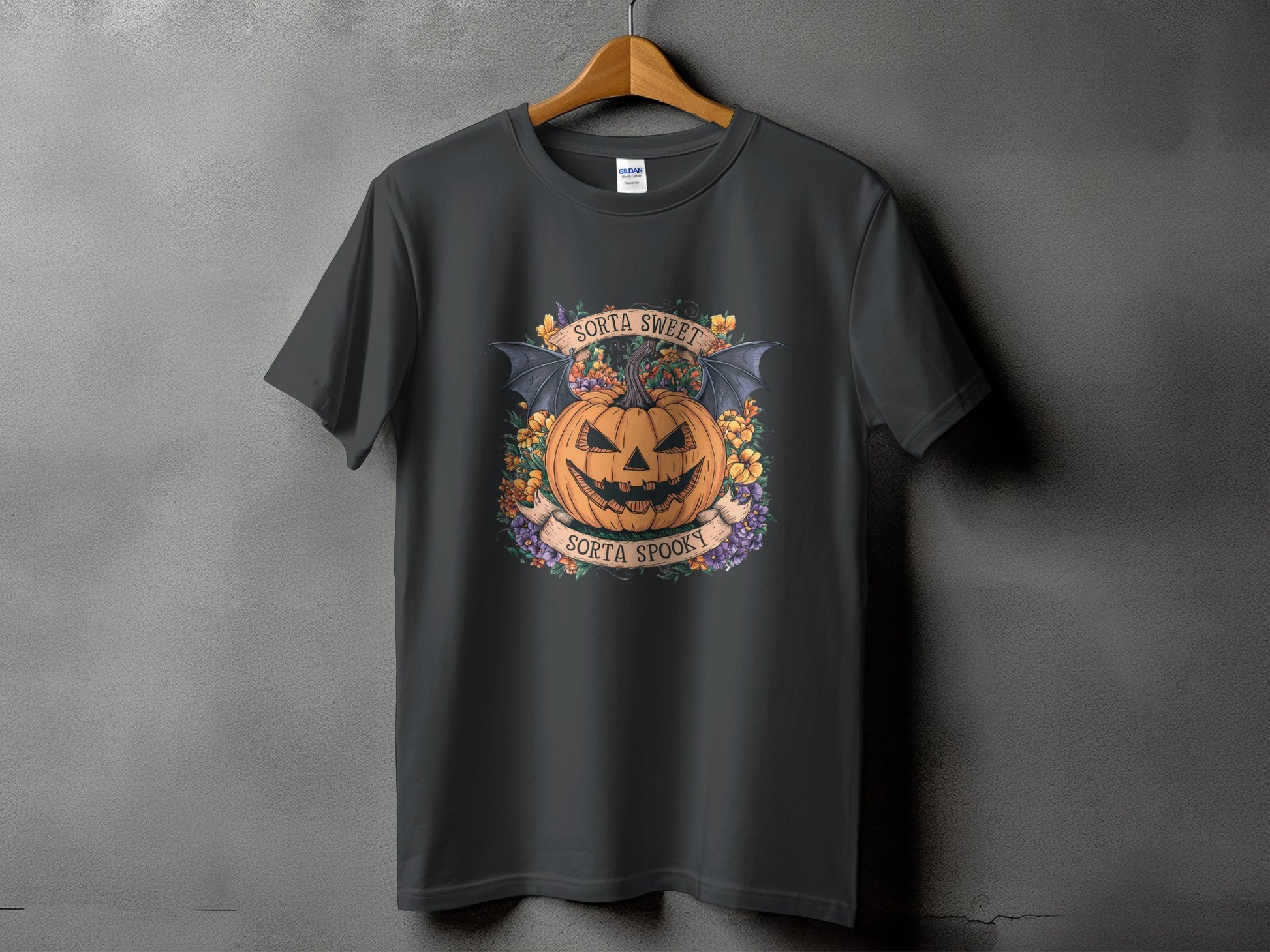 Dark gray t-shirt with a Halloween design featuring a jack-o-lantern with bat wings and text.