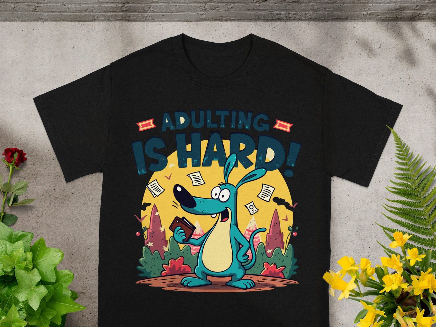 Black t-shirt with cartoon dog holding wallet and saying "ADULTING IS HARD!"