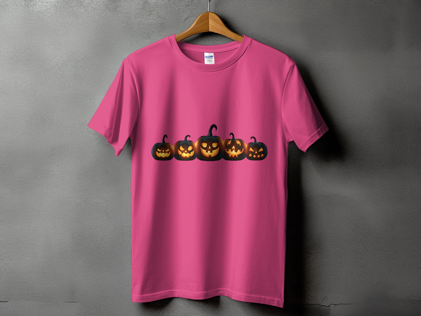 Pink t-shirt with a row of five glowing jack-o'-lanterns.