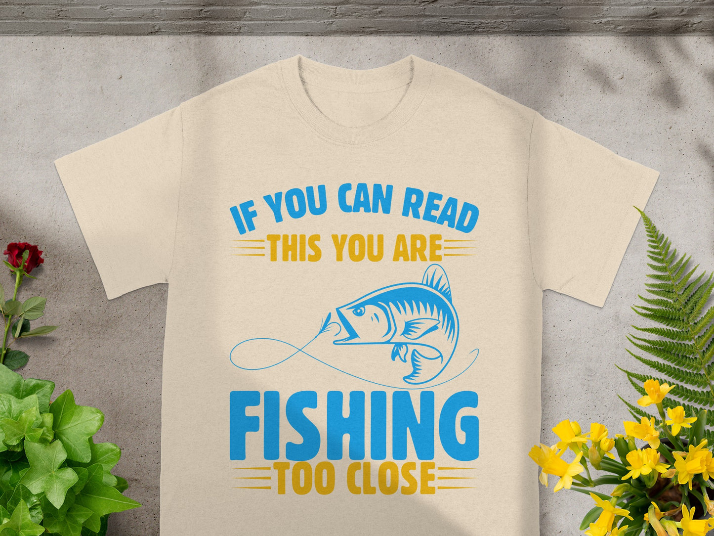 Cream t-shirt with "If you can read this you are fishing too close" text and fish graphic.