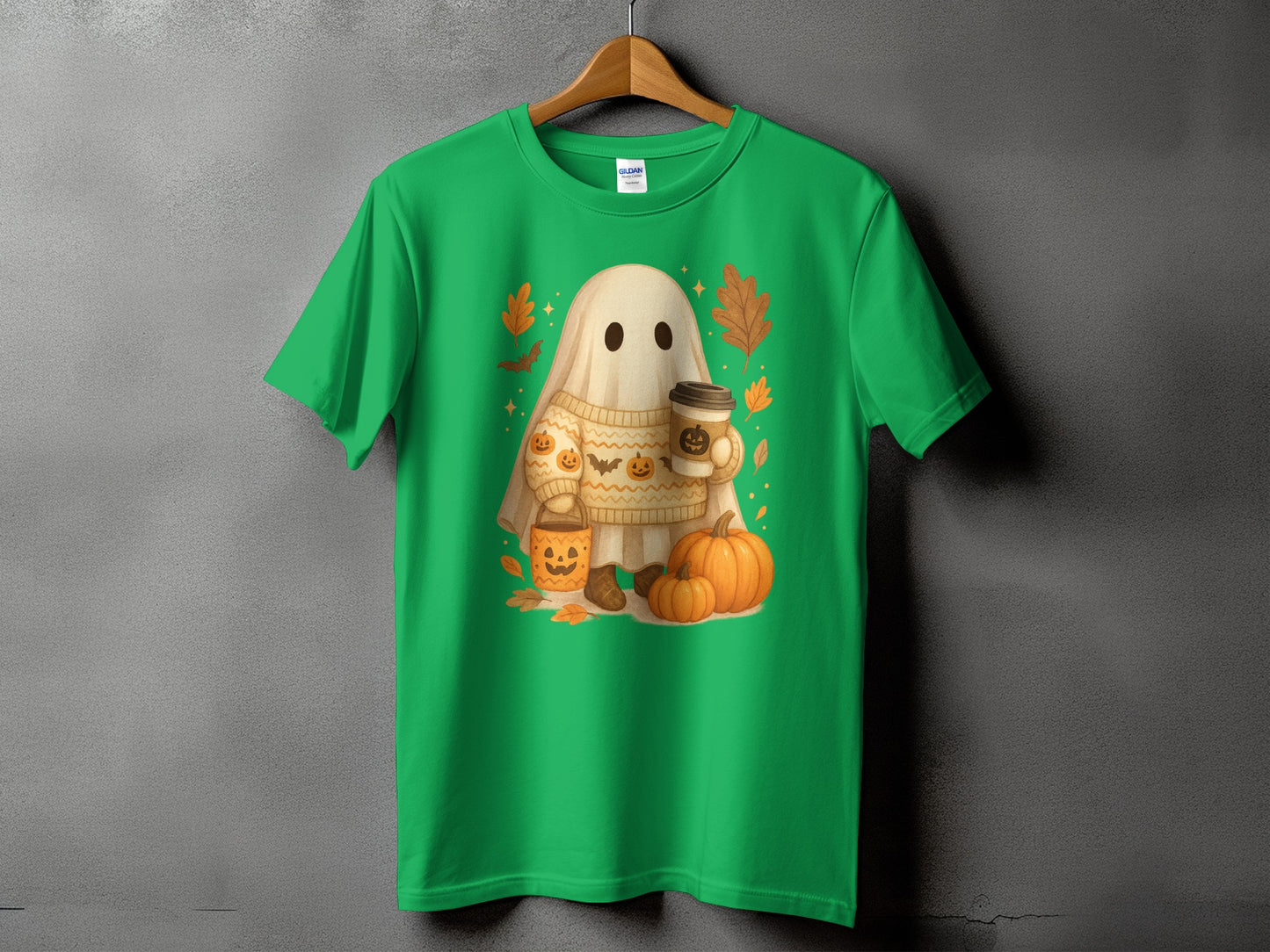 Green t-shirt with a ghost wearing a sweater holding coffee and surrounded by pumpkins.