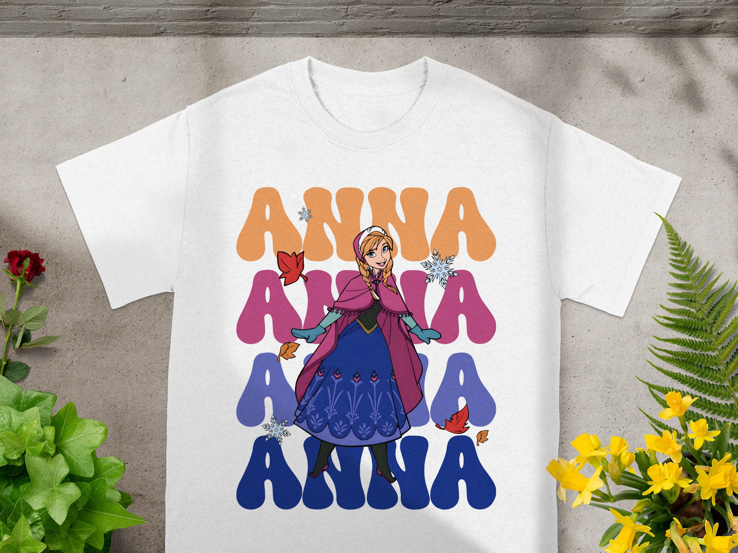 White t-shirt with Anna from Frozen and large colorful "ANNA" text.