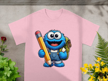 Pink t-shirt with a cartoon monster holding a large pencil.