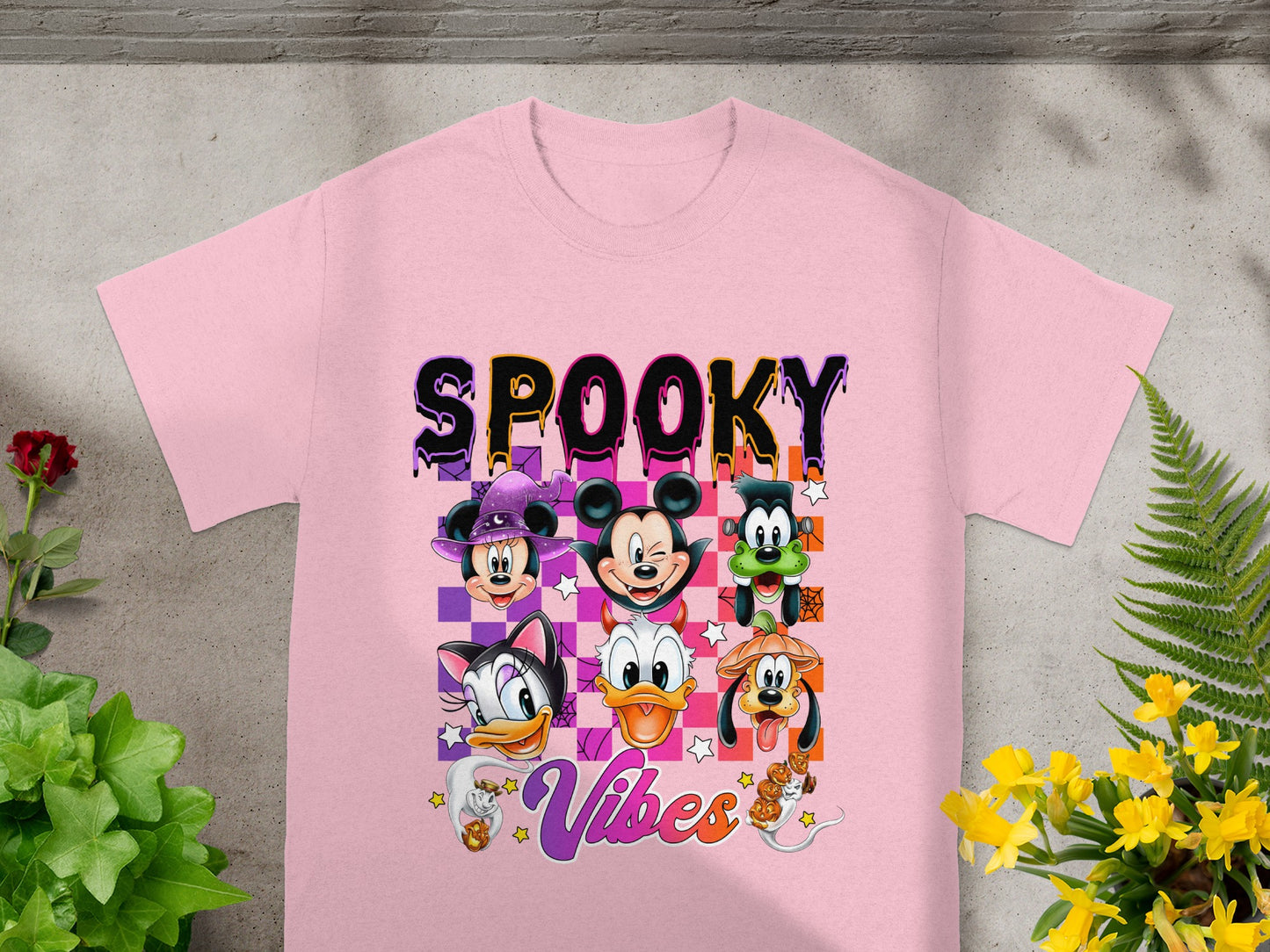 Disney characters with "Spooky Vibes" text and Halloween costumes on a pink t-shirt.