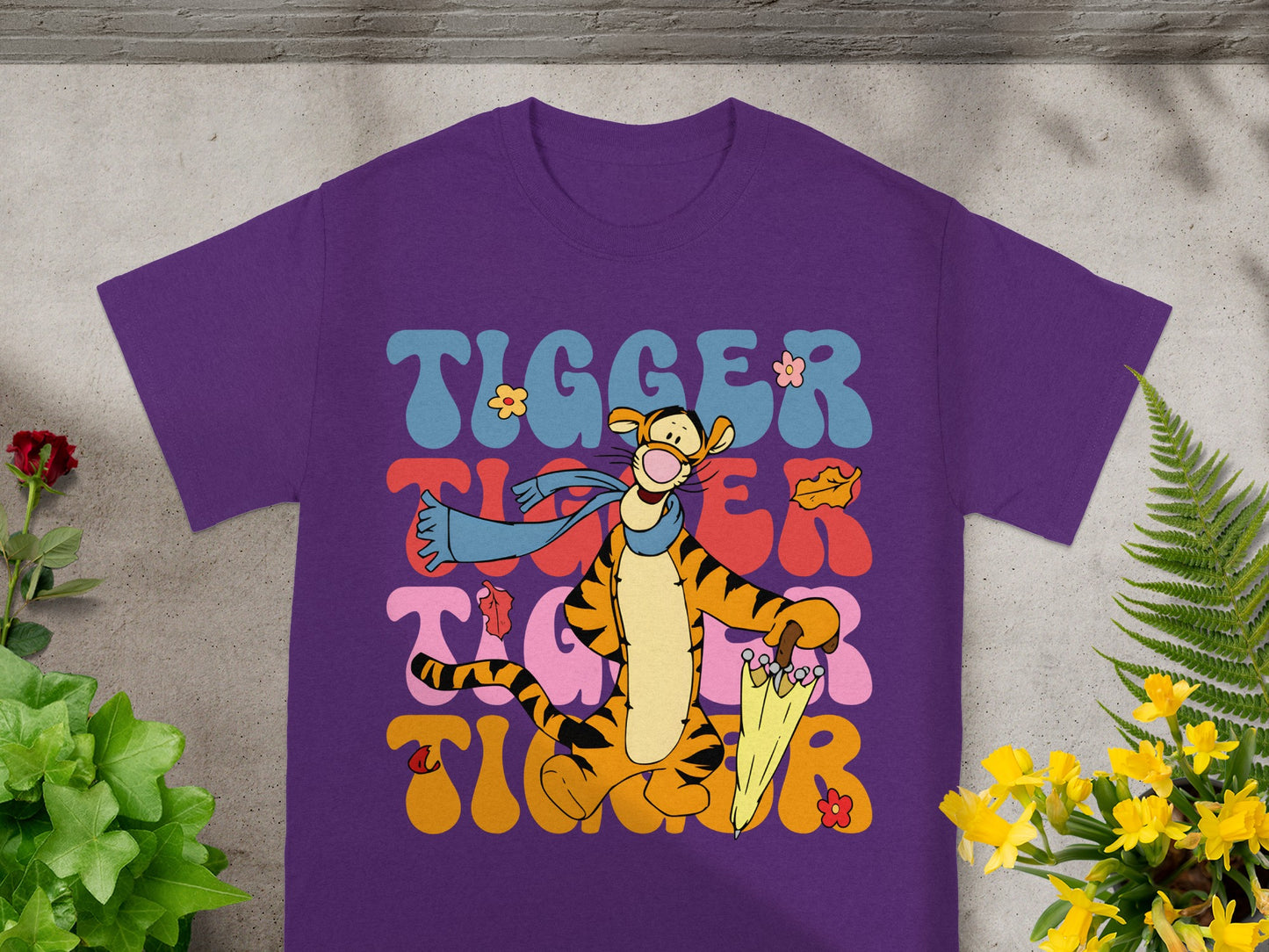 Purple t-shirt with Tigger illustration and colorful text.