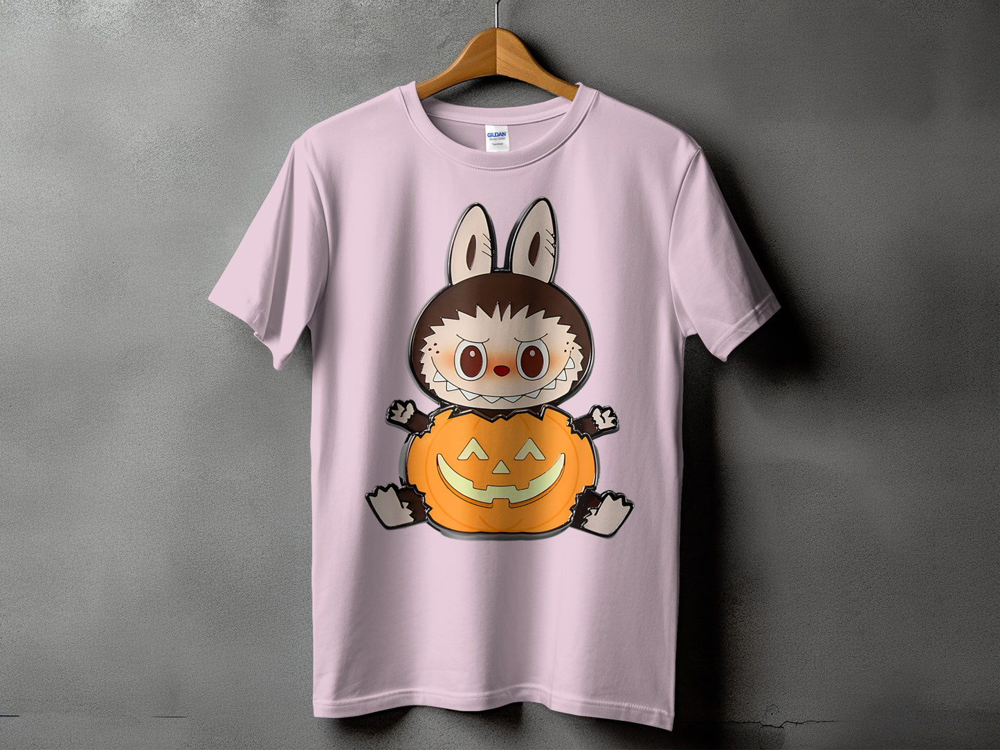 Pink t-shirt with a cartoon monster sitting in a jack-o'-lantern.