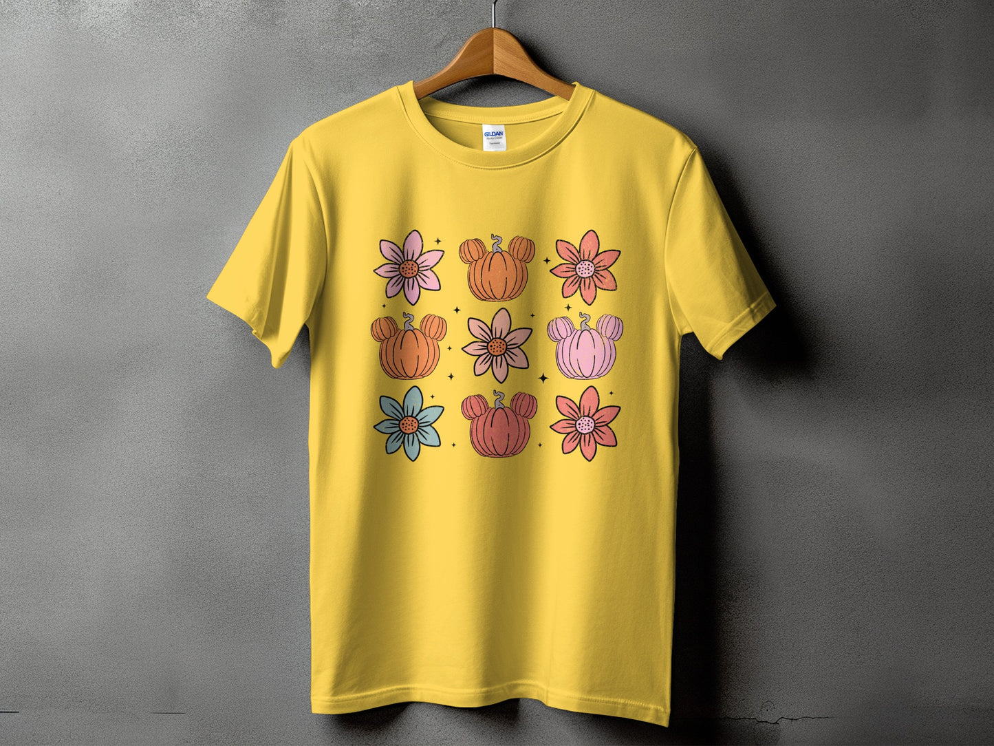 Yellow t-shirt with a grid of colorful flowers and Mickey-shaped pumpkins.