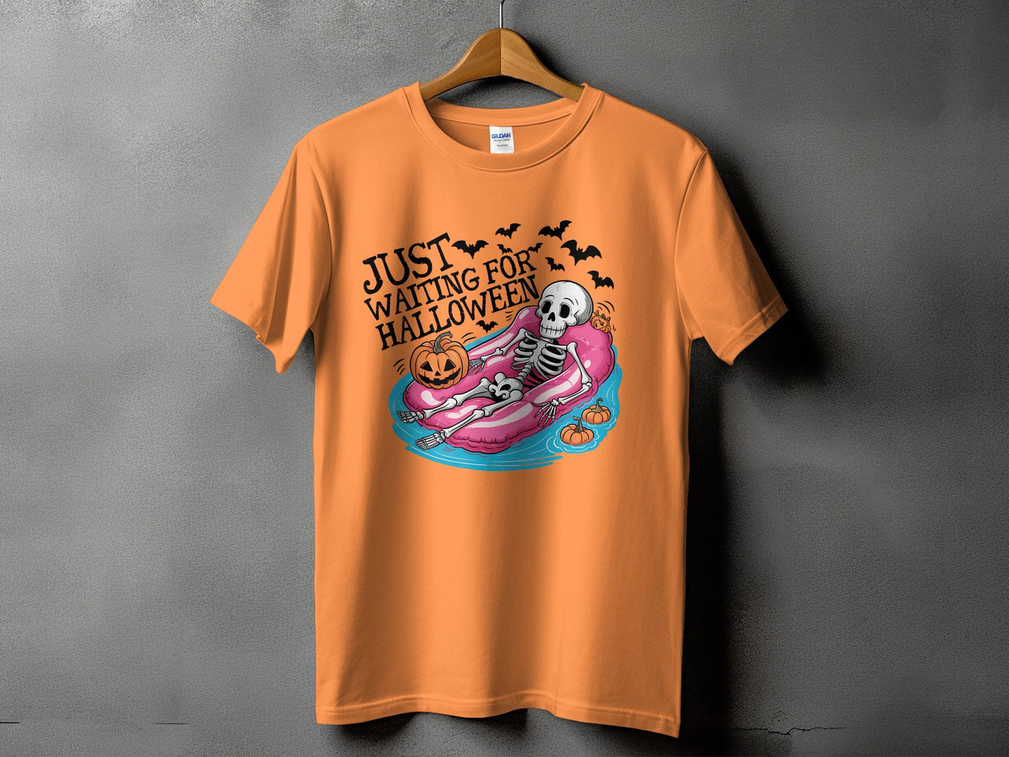 Orange t-shirt with skeleton on float and text "Just Waiting for Halloween".