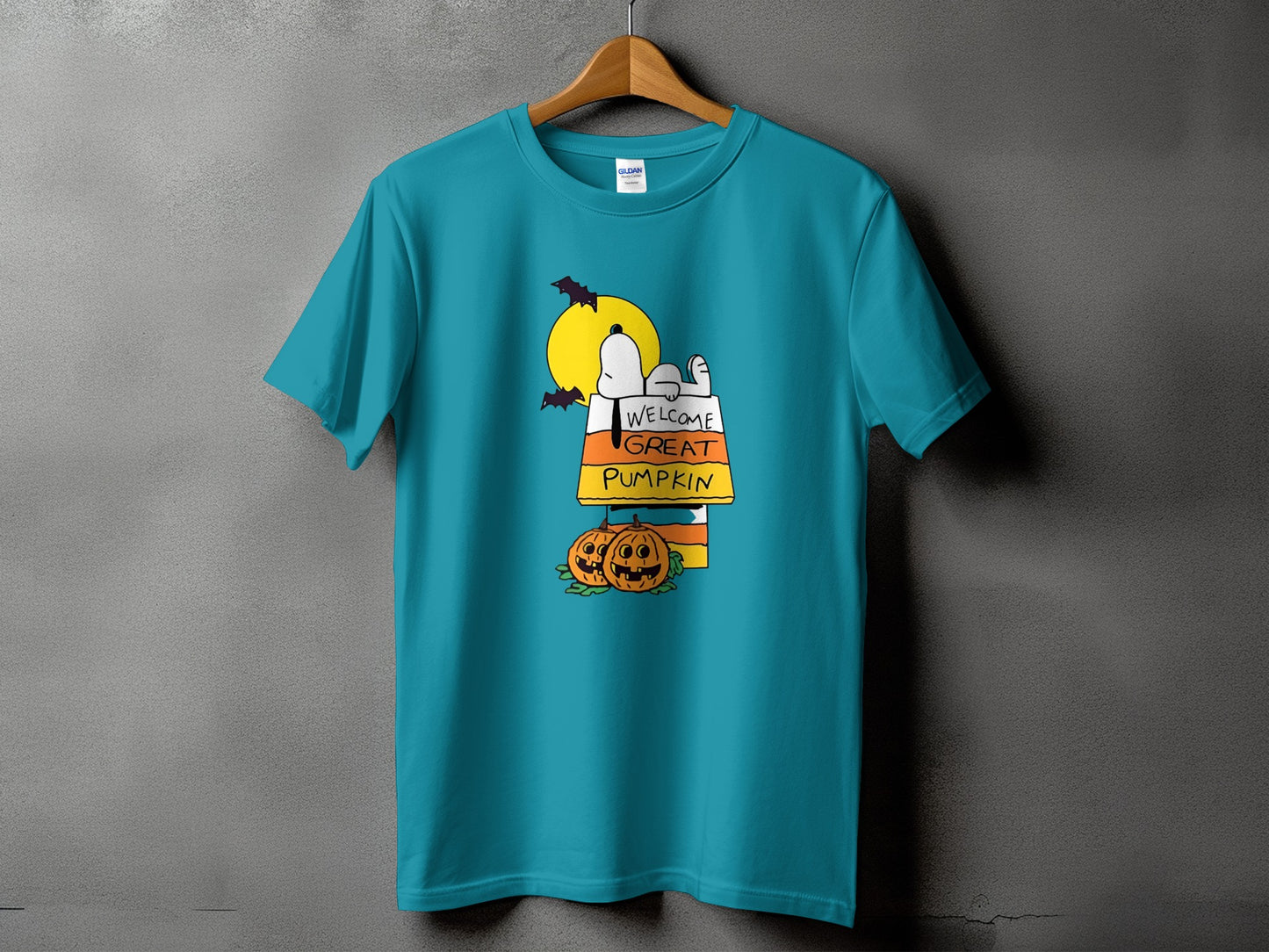 Snoopy lies on candy corn, with pumpkins and bats under a full moon.