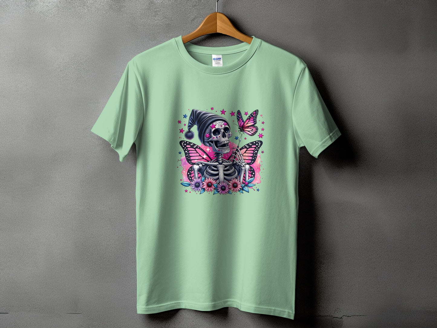 Mint t-shirt with skeleton, butterflies, flowers, and stars graphic print.