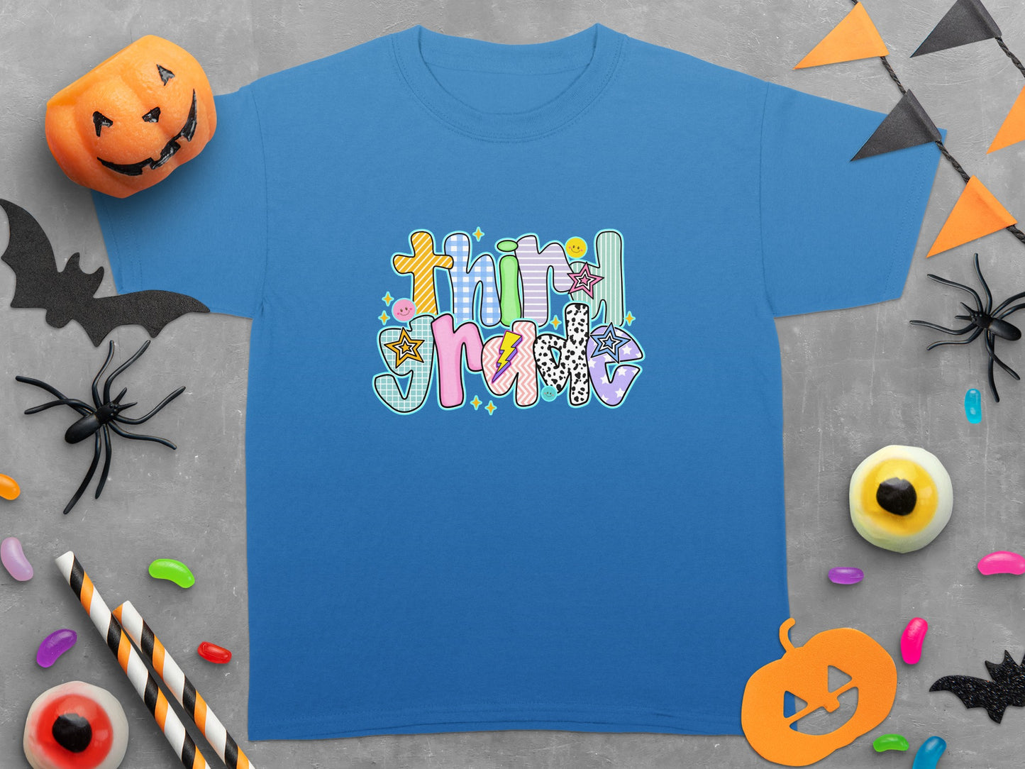 Blue t-shirt with colorful "Third Grade" graphic and Halloween decorations.