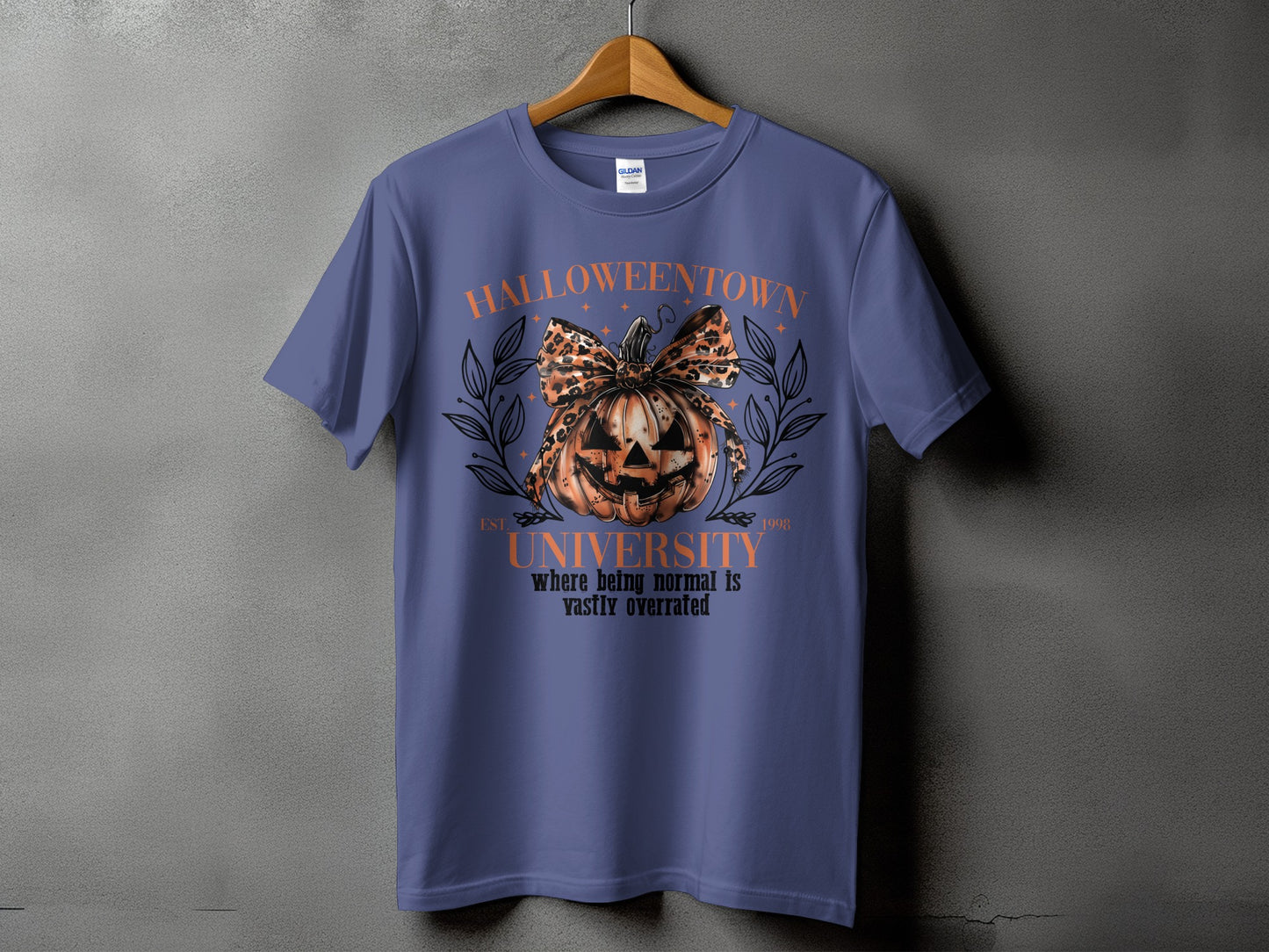 Purple t-shirt with Halloweentown University design featuring a pumpkin with leopard print bow.