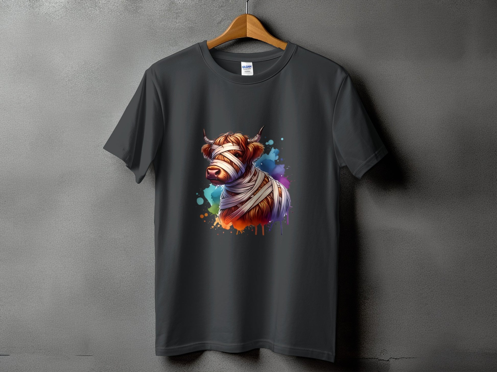 Dark gray t-shirt with a watercolor Highland cow graphic wrapped in bandages.